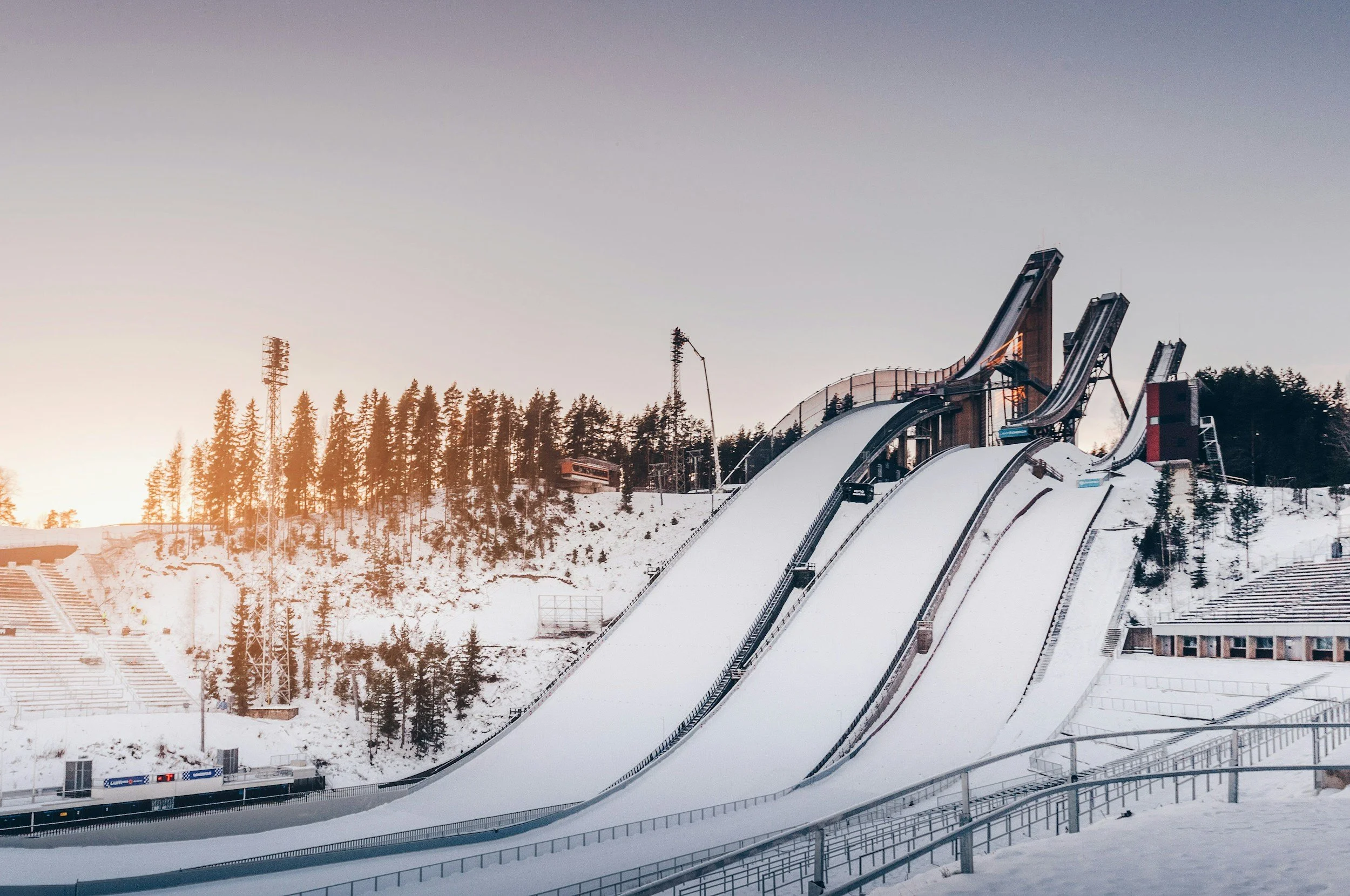 Lasketelpuisto lumisilla rinteillä auringonlaskun aikaan