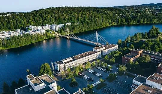 Ilmakuva kaupungin keskustasta joen rannalla, jossa on silta ja rakennuksia.