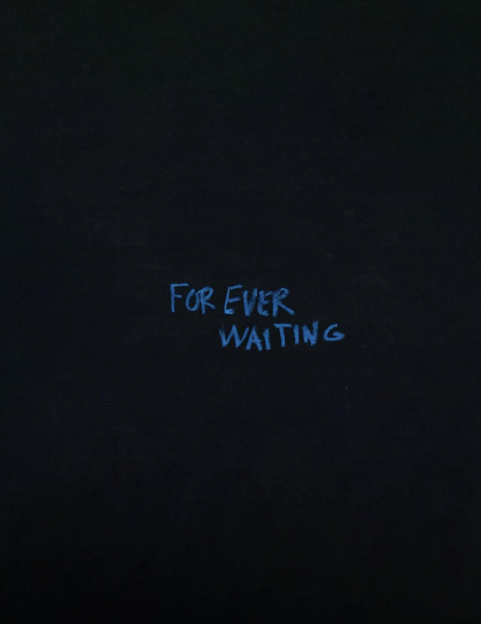 Dark background with blue handwritten text reading 'FOR EVER WAITING'.