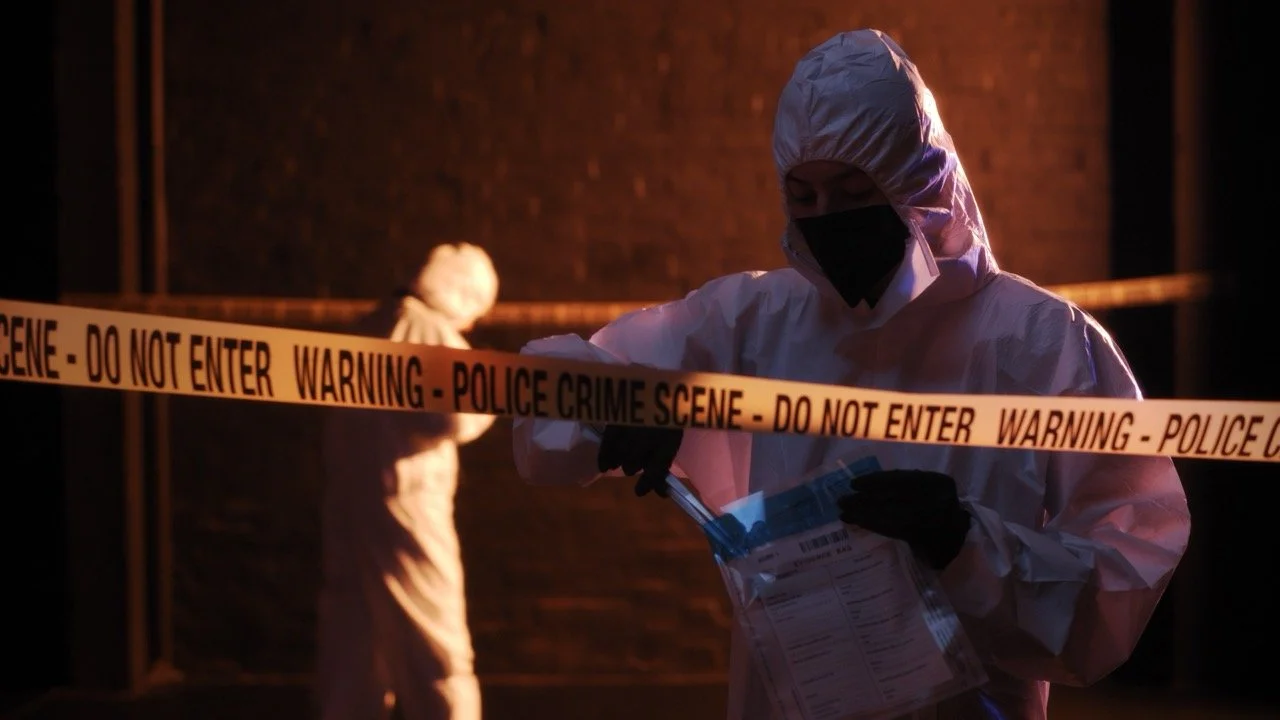 Cinematic production still of forensic investigators at a crime scene at night, from a vignette book trailer produced for a crime thriller published by a UK publisher by Gunpowder House Productions