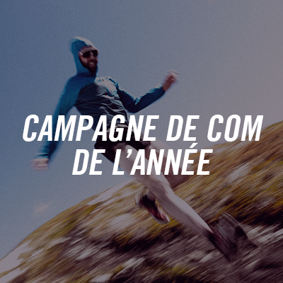 Photo of a person in mid-jump in a natural landscape with a hill and a blue sky, accompanied by the text "Com campaign of the year".