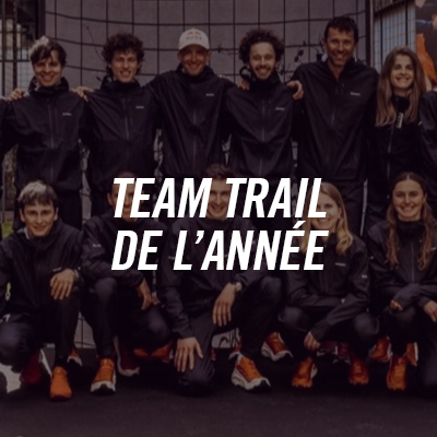 Group of Team Traïl riders of the year posing for an outdoor photo, all wearing black jackets and orange shoes.
