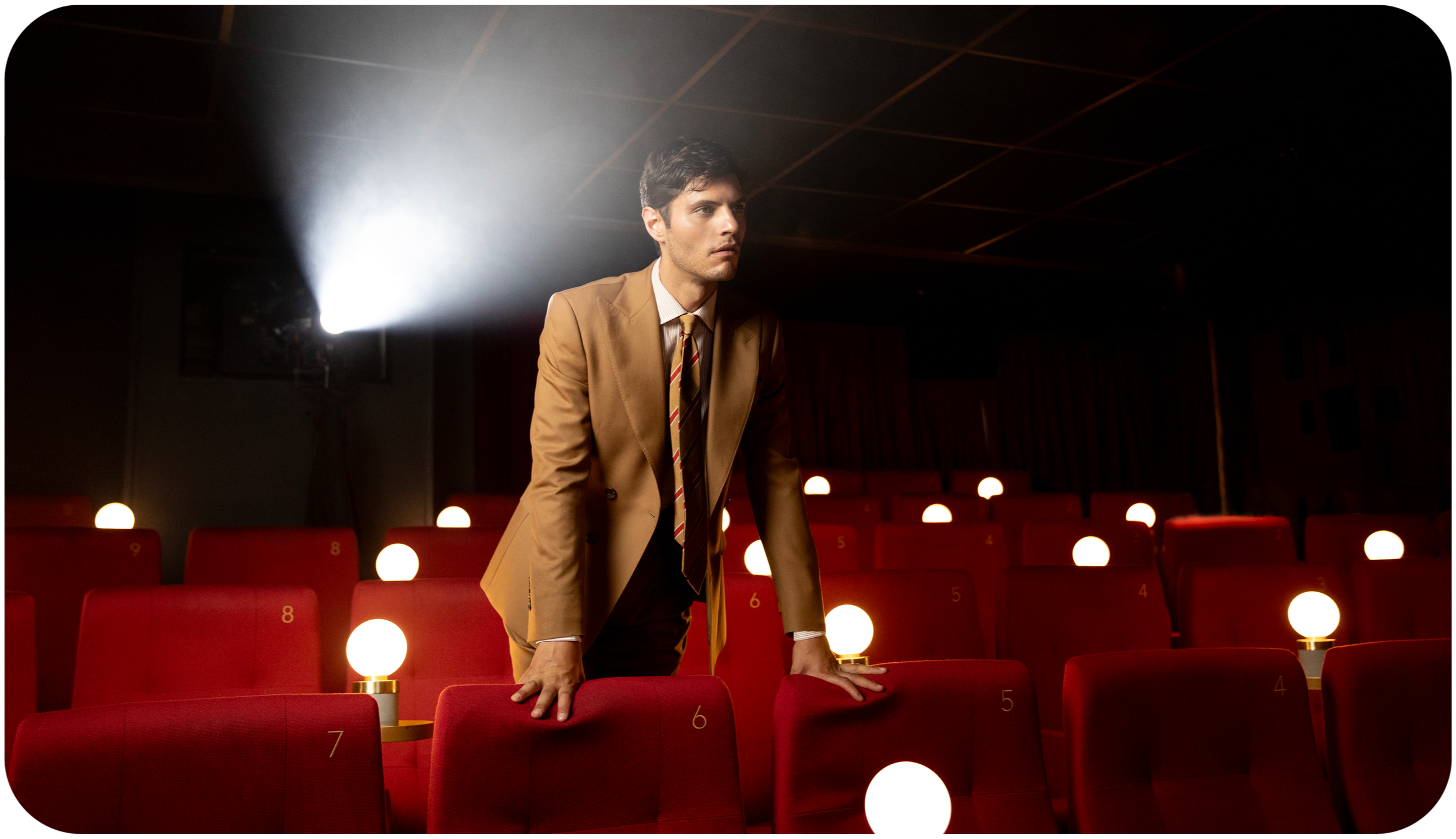 A model poses in a Savile Row suit for a fashion website at a cinema.