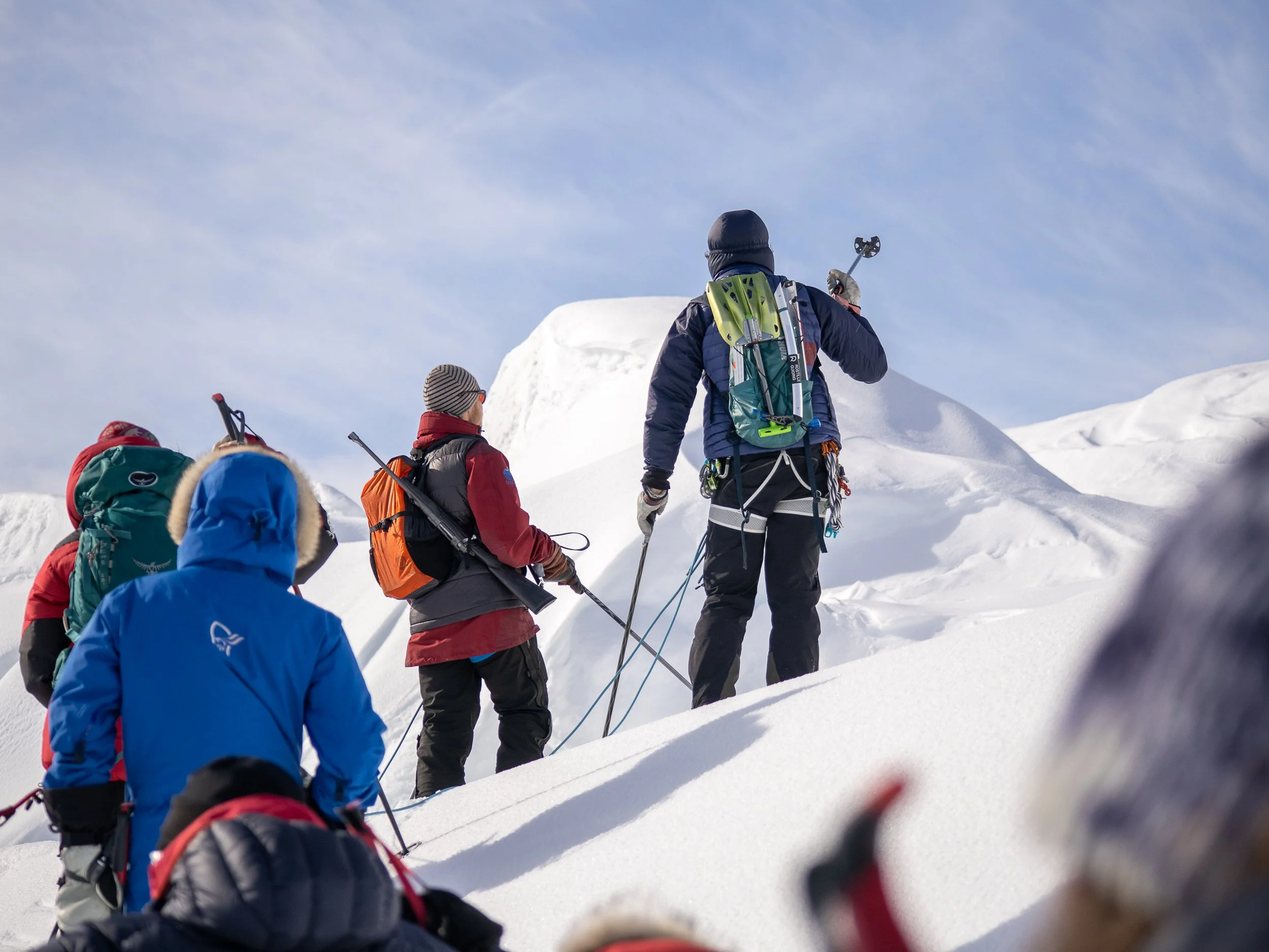 Gruppe af deltagere på Svalbard på Tværs ekspedition i gang med at navigere sig igennem et gletsjerområde.
