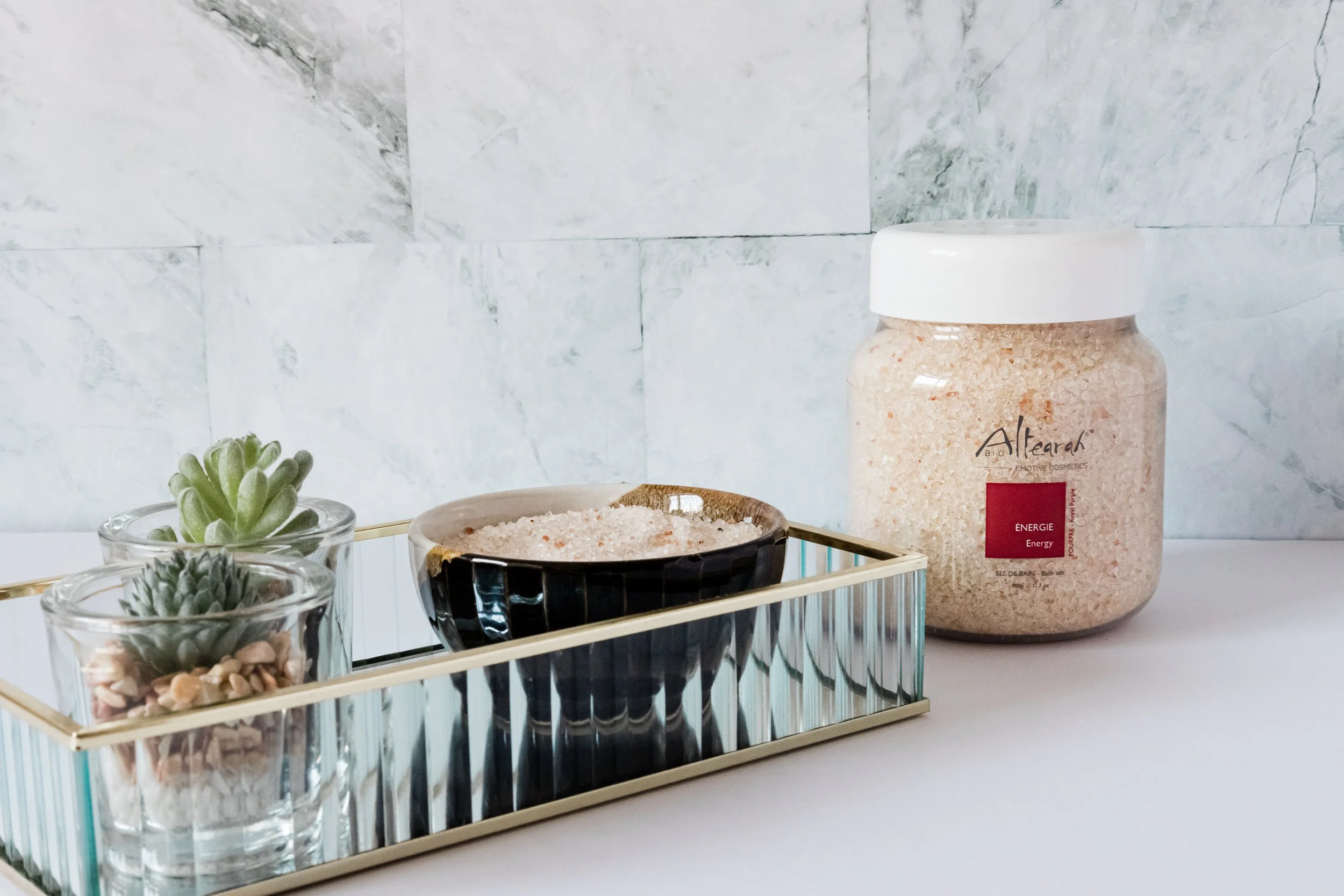 Sels de bain Altearah, symbole de détente et de bien-être avec feuillages verts dans une ambiance apaisante.