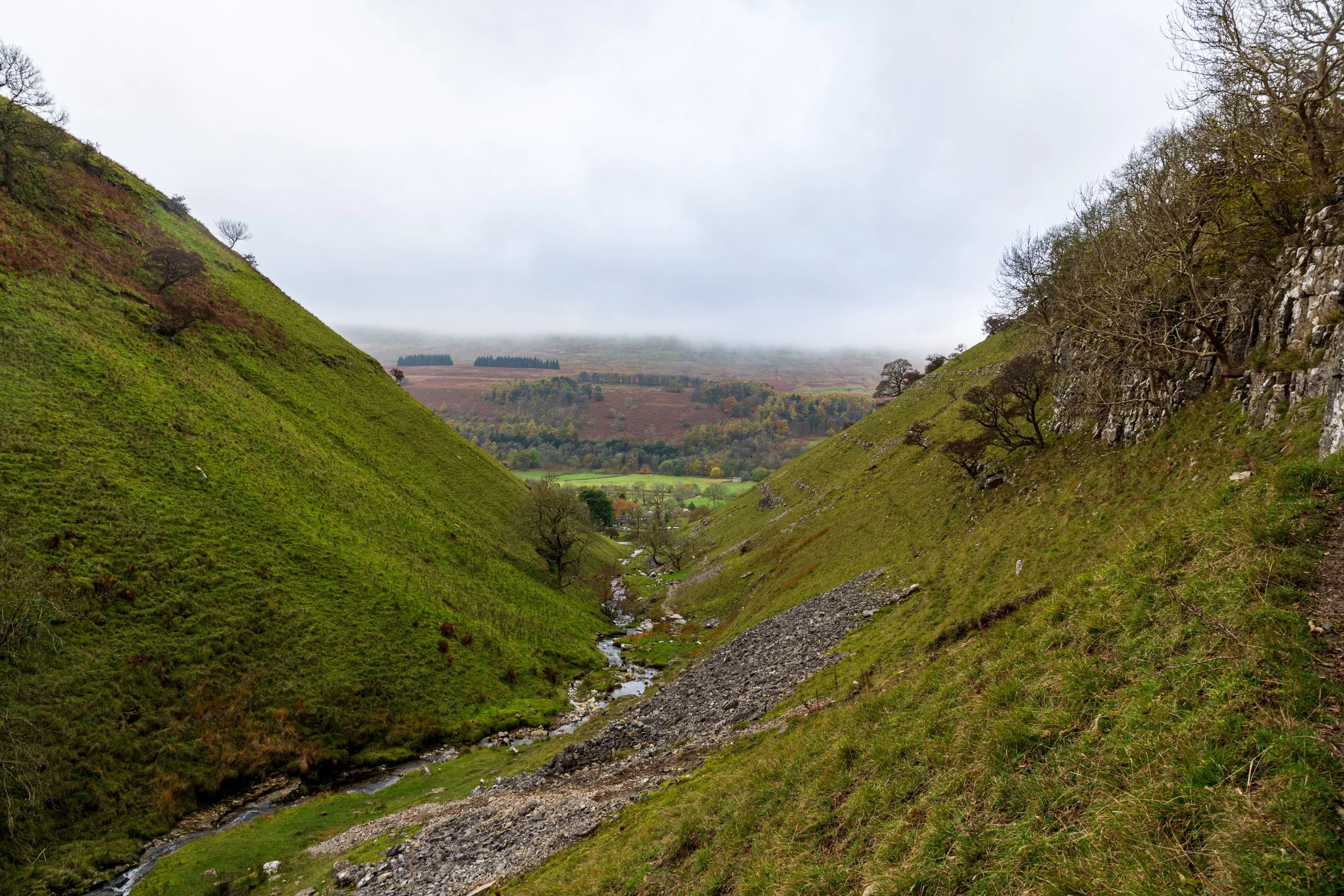 A view along Buckden Beck and into Wharfedale, with Birks Fell opposite shrouded in mist
