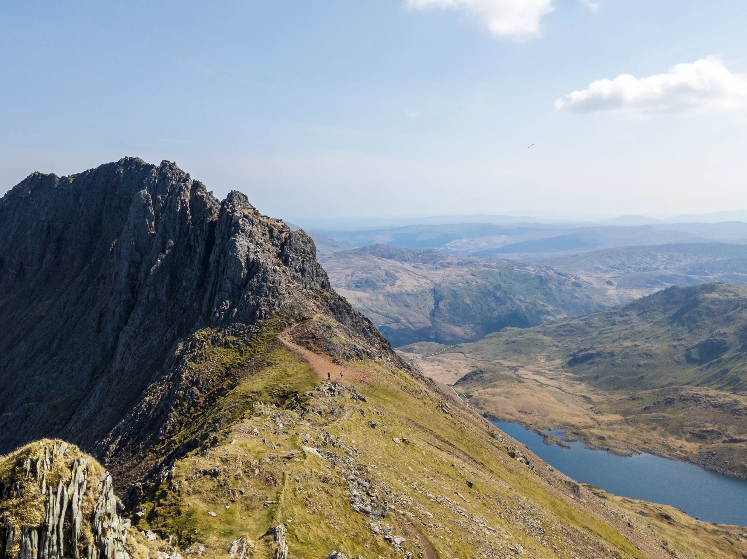 The pinnacles at the end of the Crib Goch ridge on sunny day, with Llyn Llydaw in the background