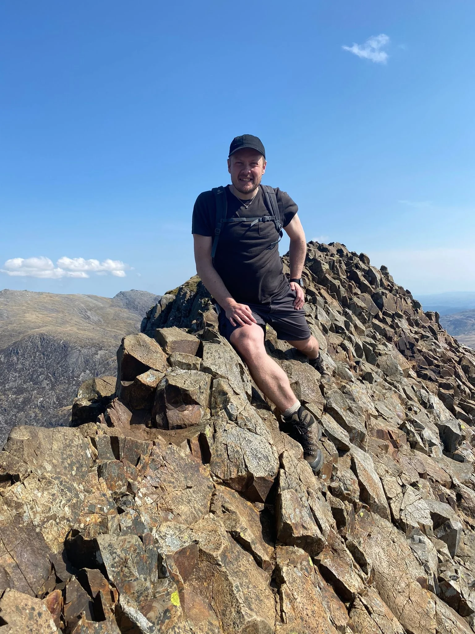 Ant sitting on top of the Crib Goch ridge against a blue sky