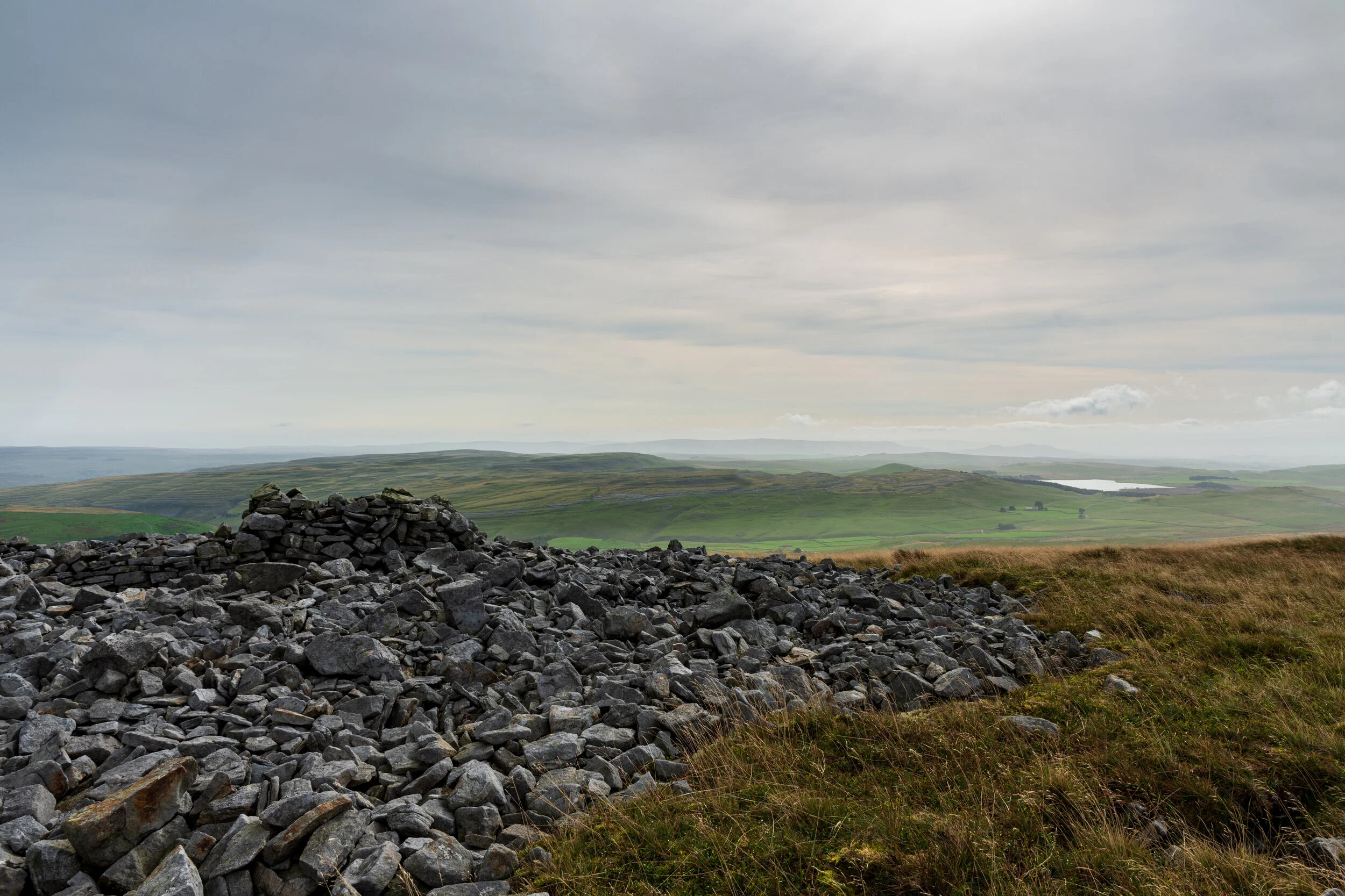 The disused weather station below the summit, with Malham Tarn in the distance