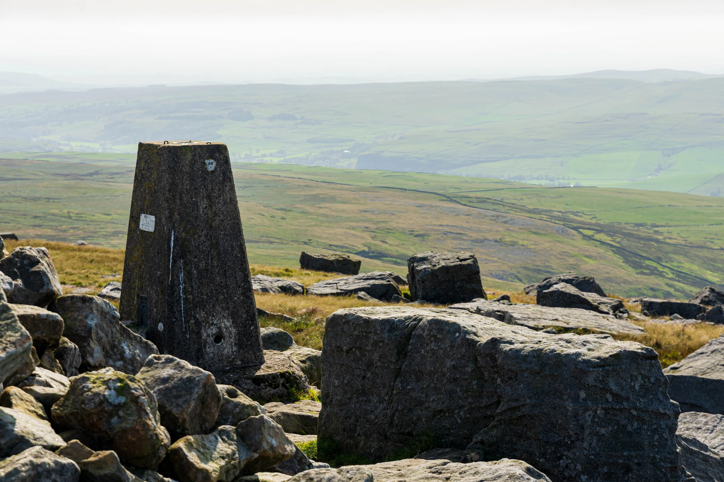 Rocky top of Great Whernside, overlooking a hazy Wharfedale