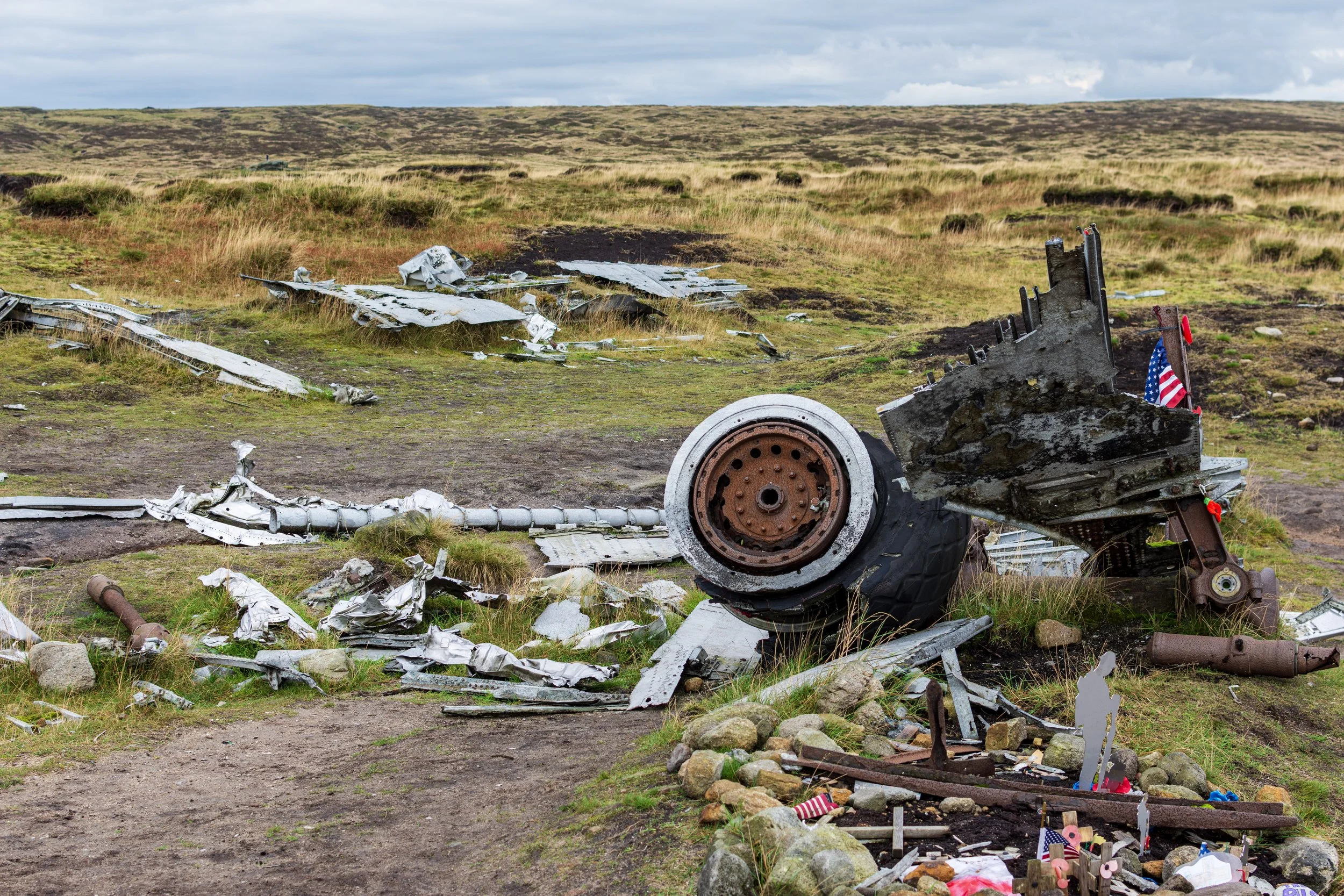 Wreckage from the B29 Superfortress 'Bleaklow Bomber' at Higher Shelf Stones in the Peak District. Possibly a flywheel or hub from the landing gear. Partial wings in the background. US flags makring the site
