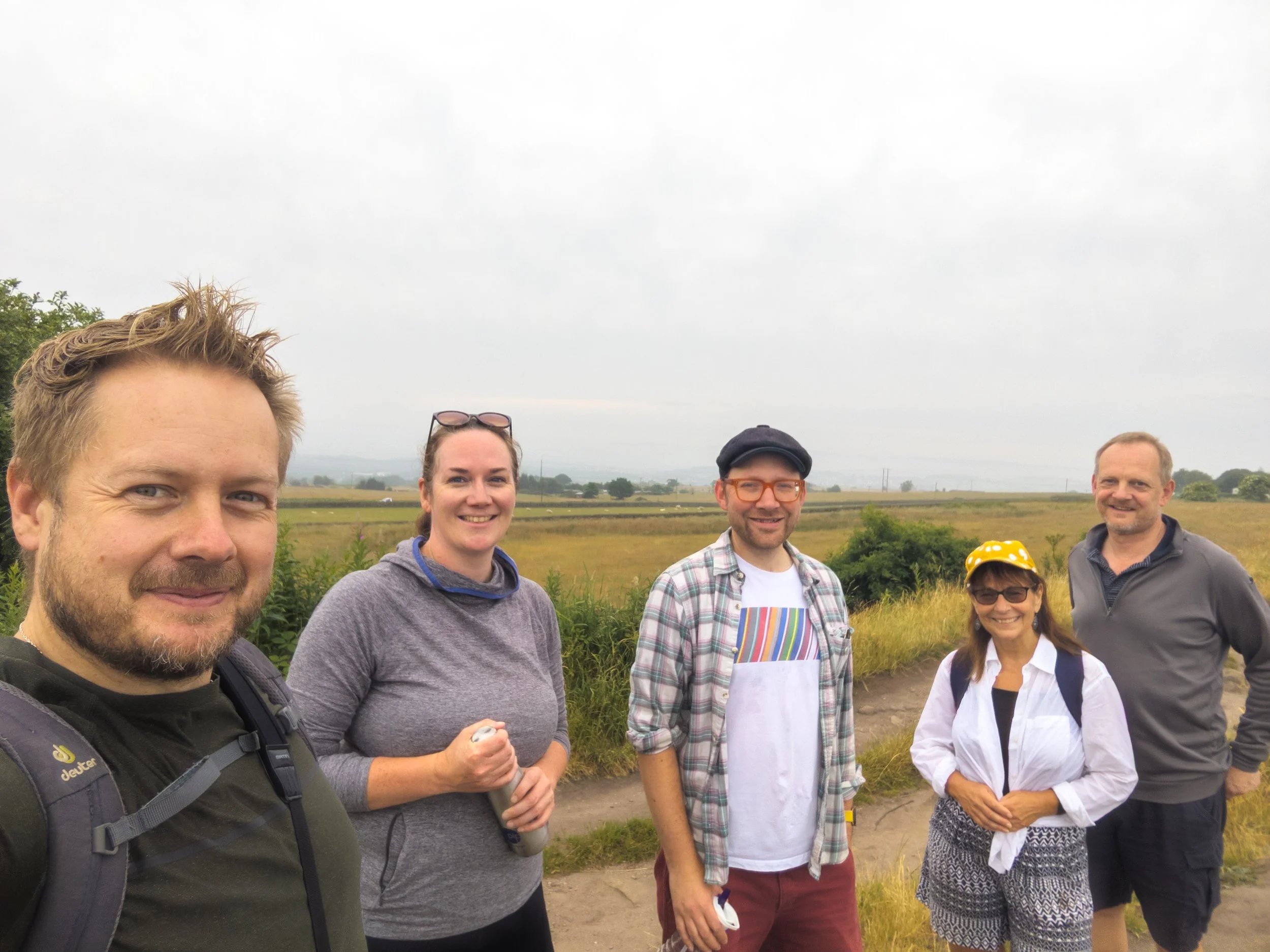 Anthony Ackers and four attendees of a Mountain Boardroom Wellness Walk standing on an overcase Surprise View at the top of Otley Chevin