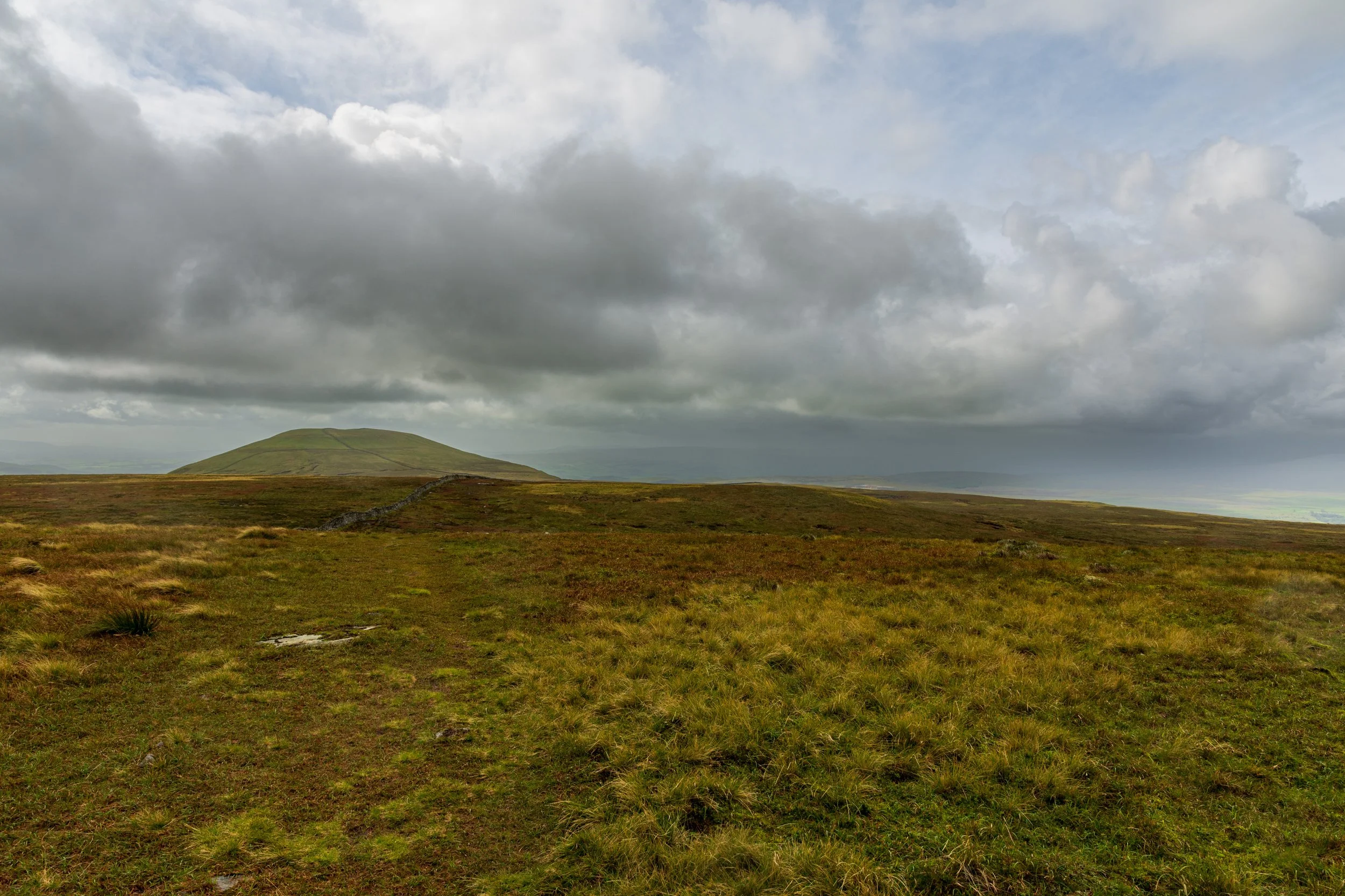 The summit of Pen-y-Ghent viewed from the summit of Plover Hill, under a brooding, cloudy sky