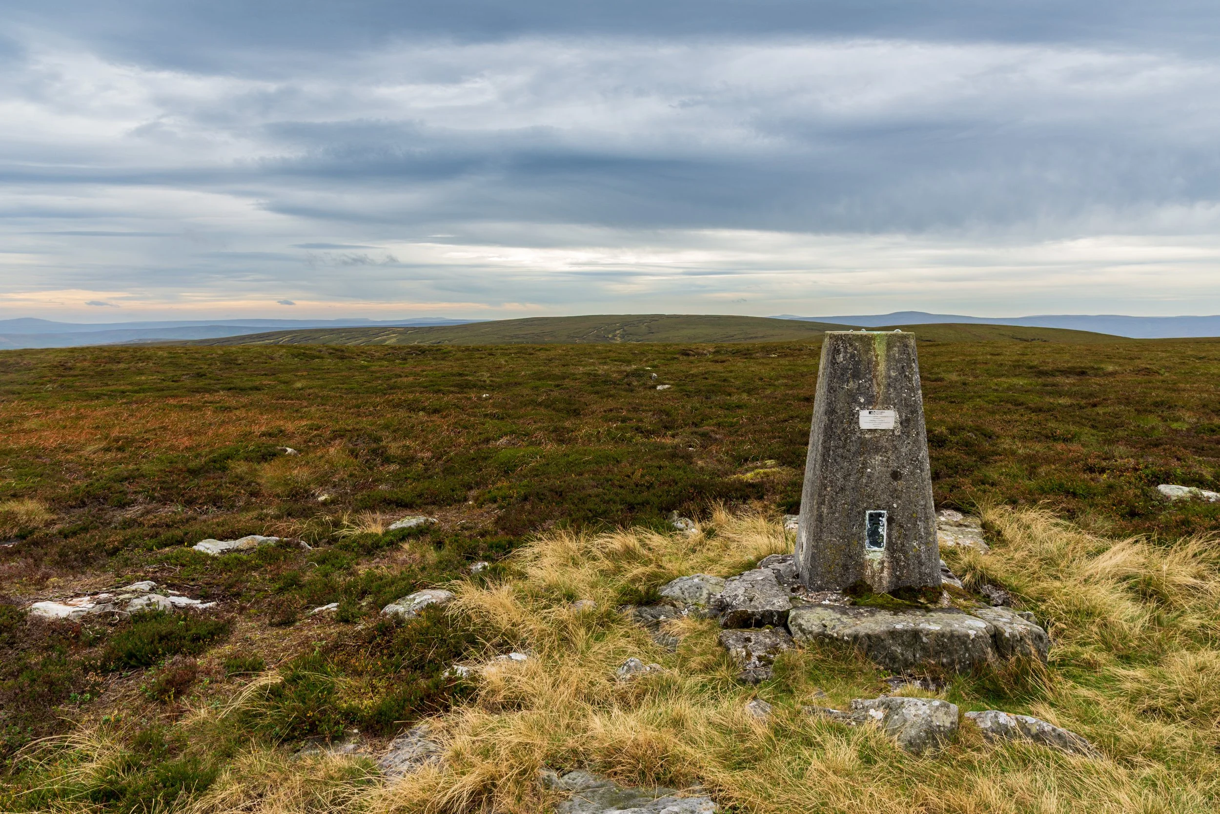 Triangulation Pillar/Trig Point ref 2963, near the summit of Rogan's Seat, with the summit in the background, and Whernside in the distance