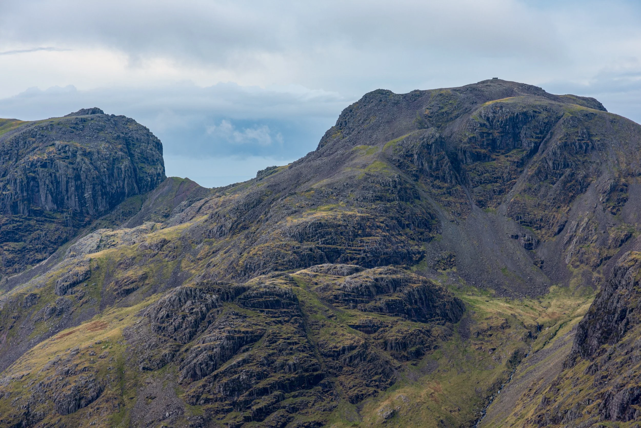 A close up of Scafell and the towering crags Broad Stand on the left, and Scafell Pike in the Lake District and Rough Crag to the right. Very rocky, cloudy but fine day.