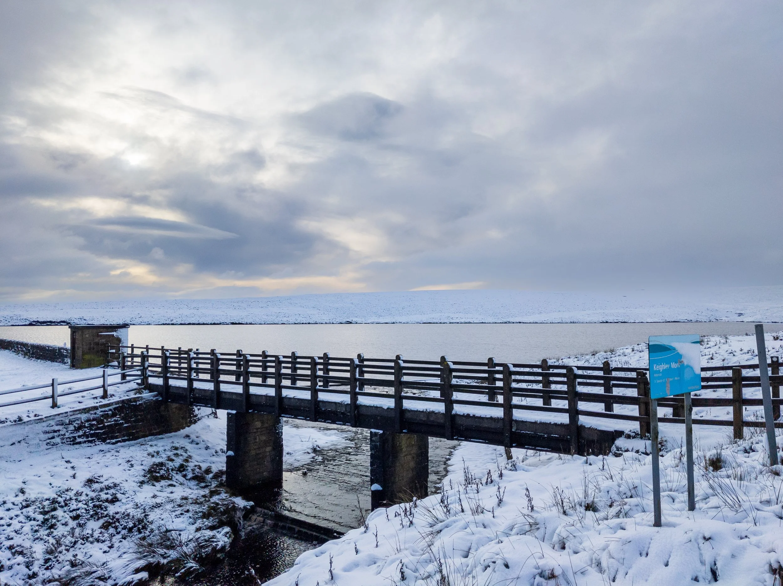 Keighley Moor reservoir near Wolf Stones, on the snow covered moor, against a dramatic winter sky