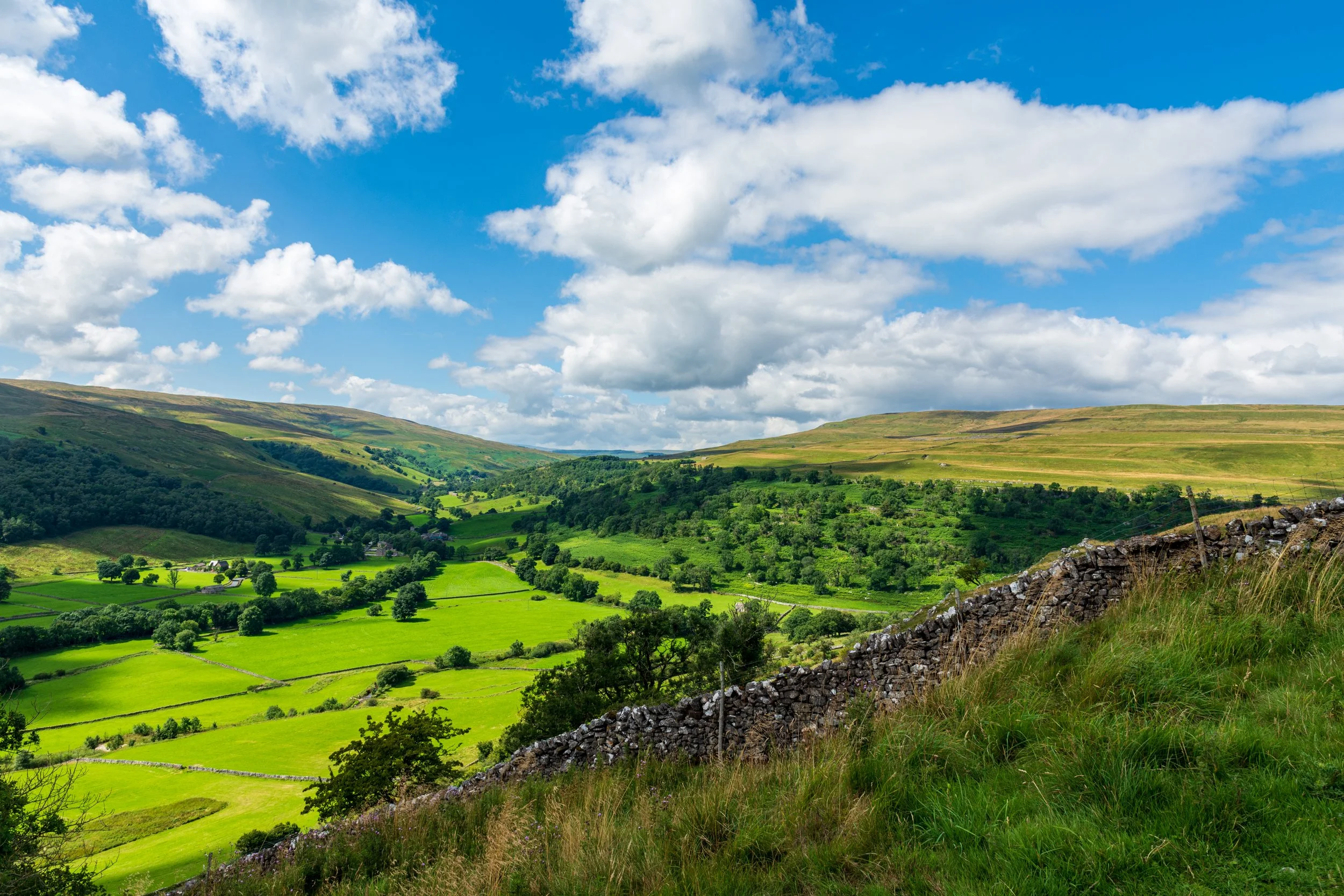 Upper Wharfedale on a sunny day, with Yockenthwaite Moor on the right and Birks Fell on the left