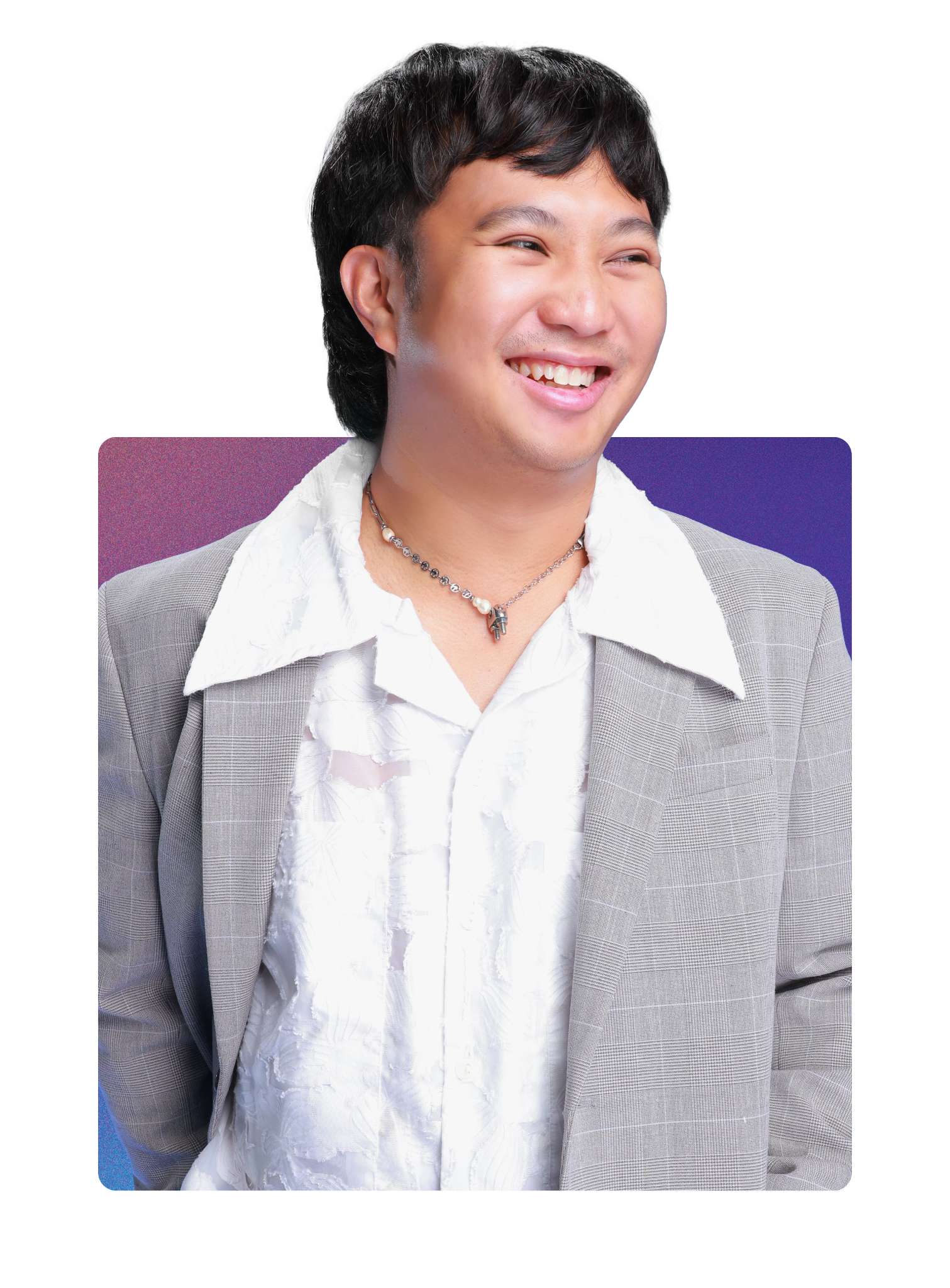 A man with black hair wearing a gray plaid blazer, a white textured shirt, a necklace, and smiling.