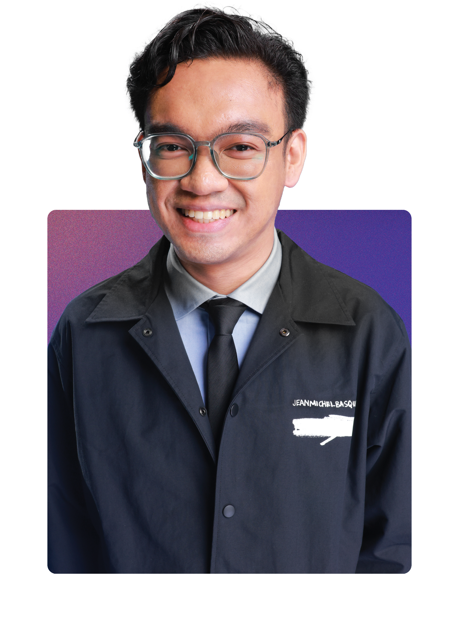 A young man wearing glasses, a light blue shirt, a black tie, and a black coat with text on it, smiling and facing the camera.