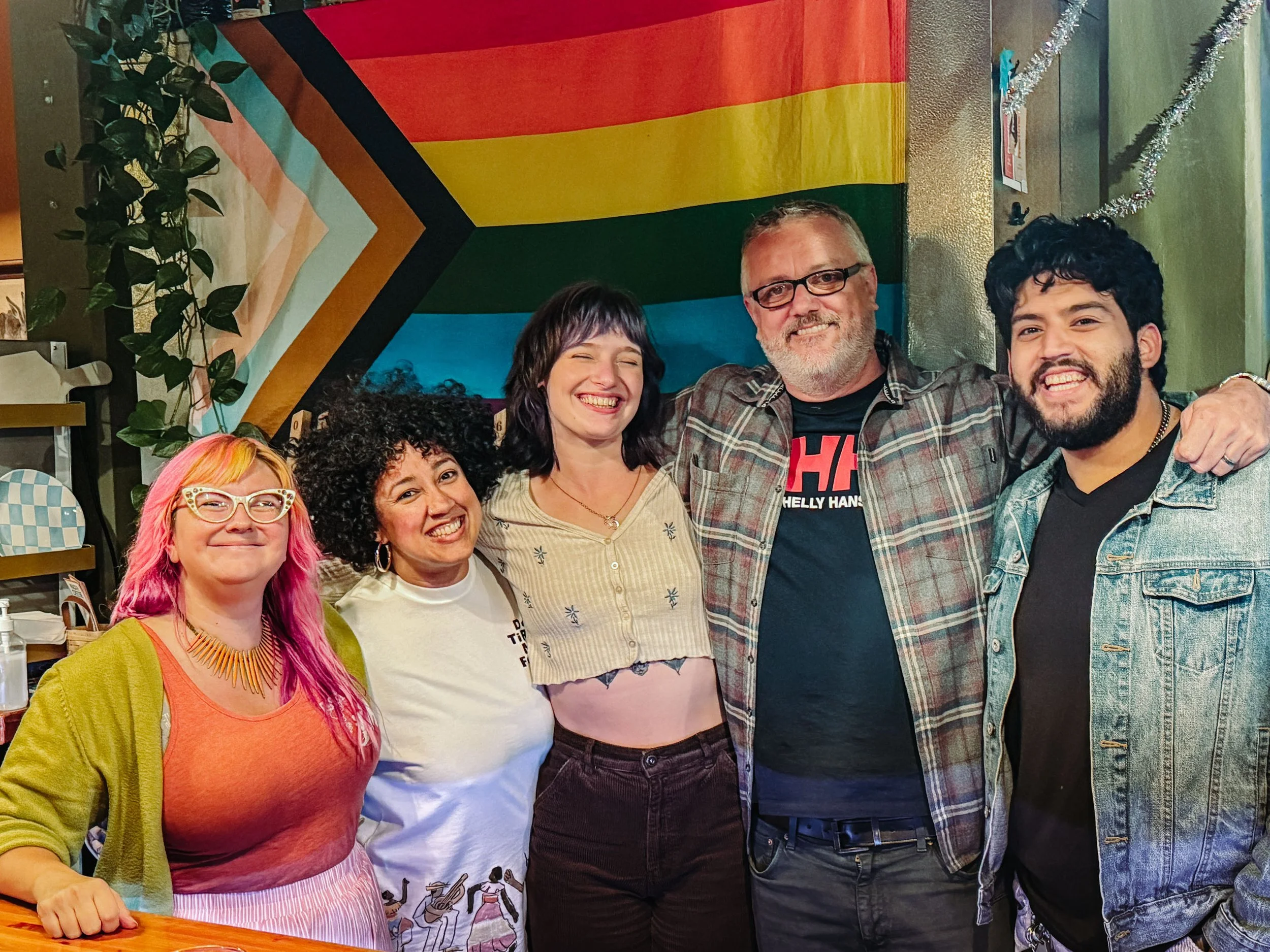 Bitter Monk McMinnville craft beer bar beertenders standing in front of craft beer taps, with an rainbow pride flag in the background