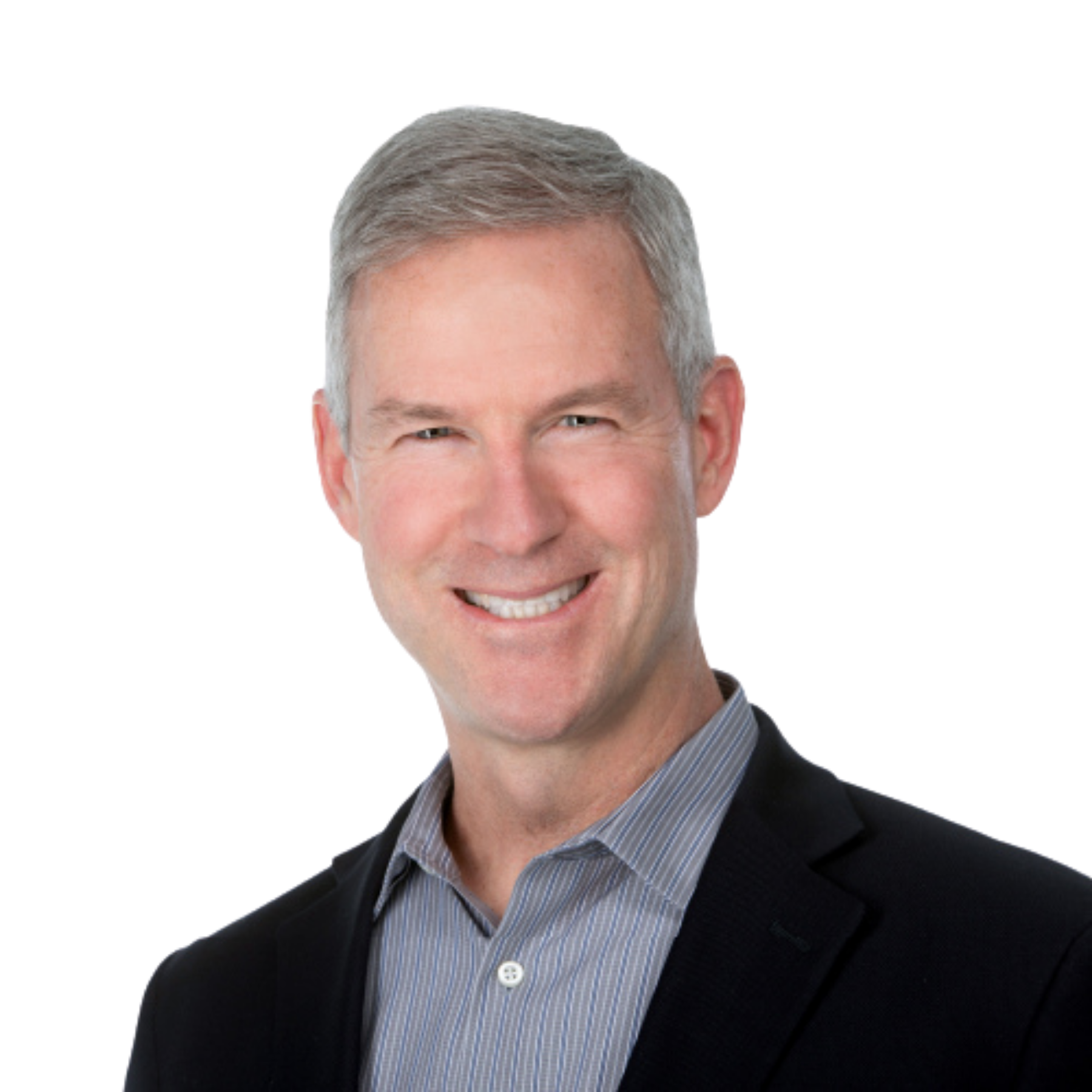 Close-up of a smiling man with short gray hair, wearing a dark blazer over a light blue striped shirt, against a plain background.