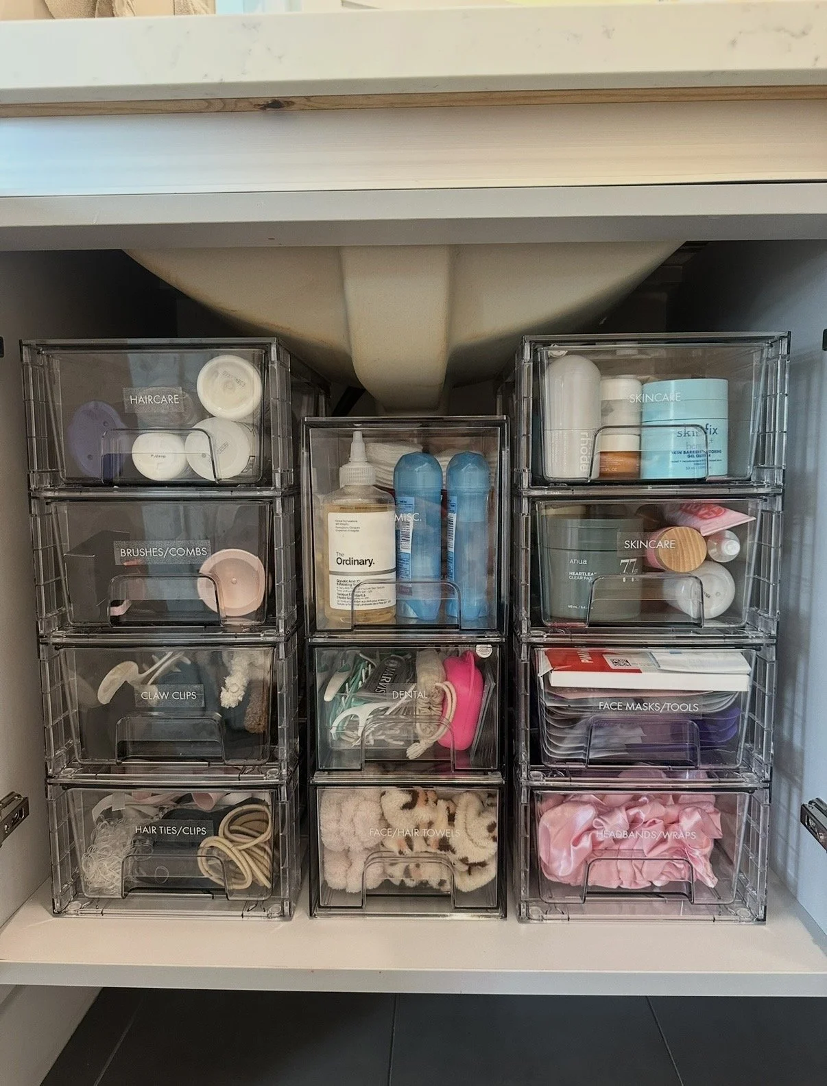 Clear plastic drawers labeled for healthcare, brushes, dental, hair ties, skincare, face masks, headbands, and face/hair towels, containing various personal care items.