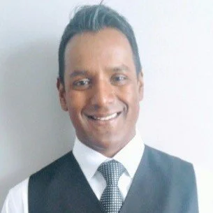 Portrait of a man in business attire with a white background.