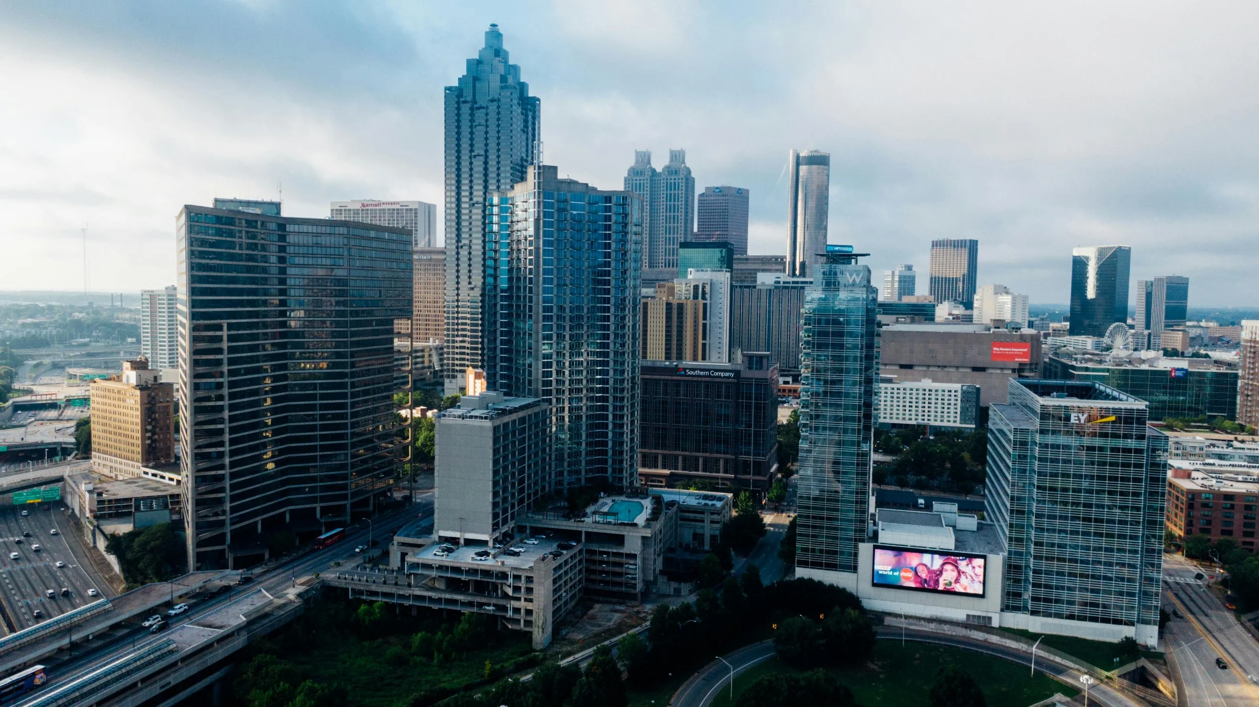 Downtown cityscape with tall skyscrapers, highways, and a digital billboard