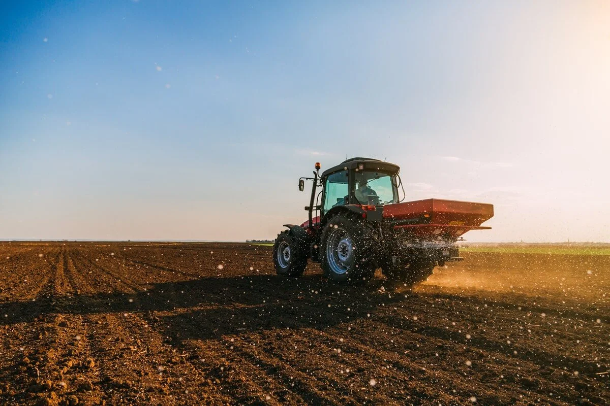 Tractor spraying fertilizer in a field
