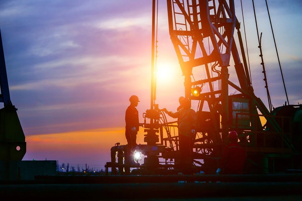 Workers around equipment at oil drilling site
