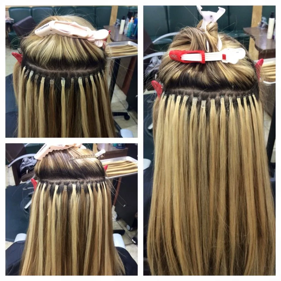 A person getting their hair extensions taped in a salon. The process involves attaching wefts of hair to natural hair close to the scalp.