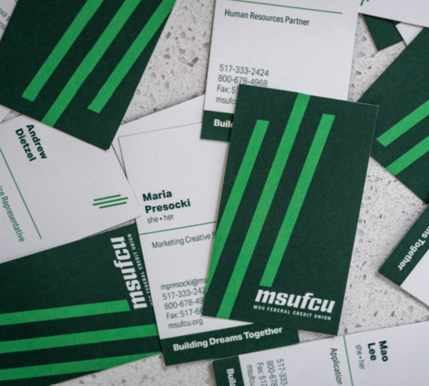 Business cards in a random arrangement to showcase MSUFCU's new branding