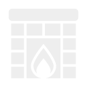 A fireplace with a black brick chimney and a lit fire inside.