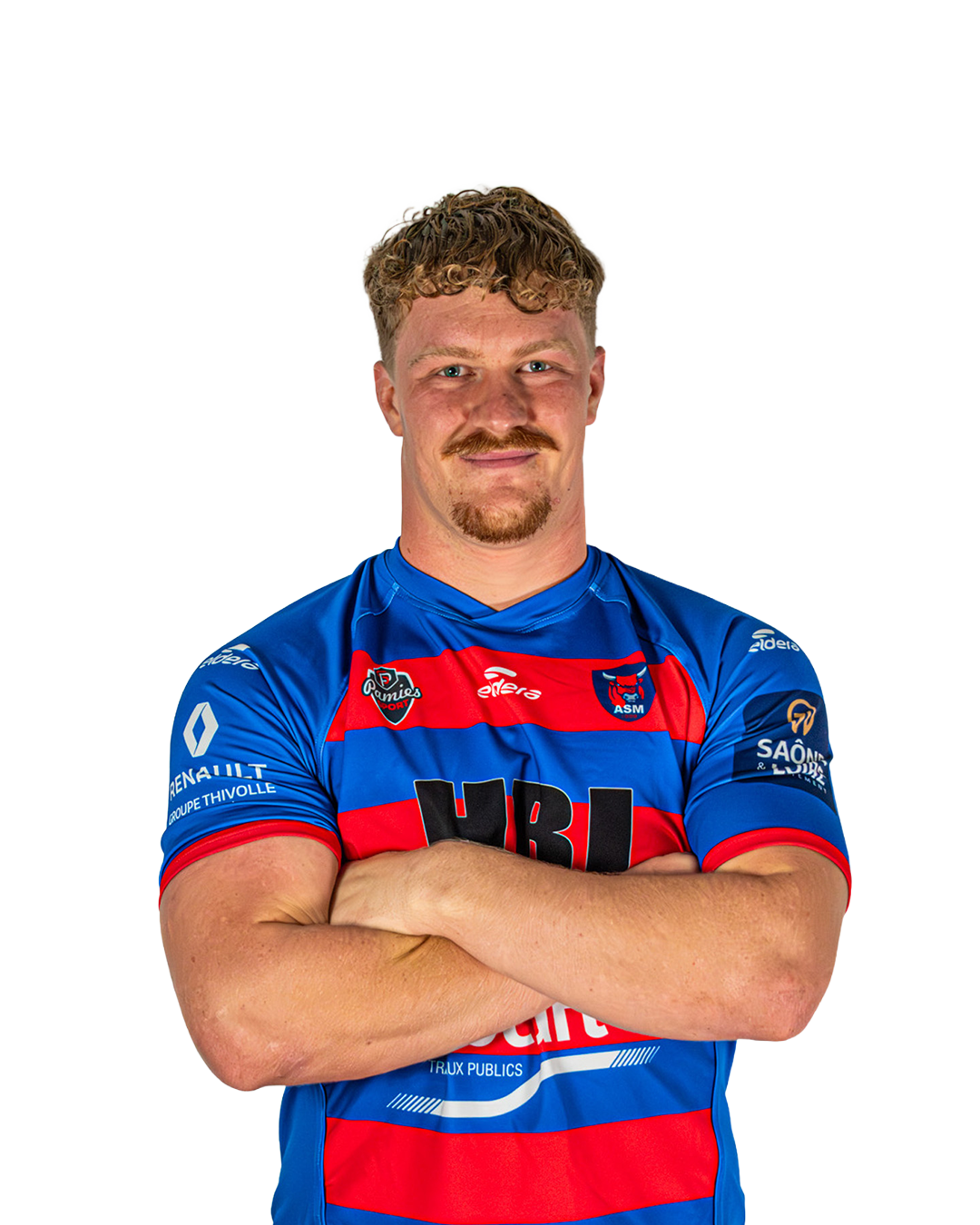 Un joueur de rugby en maillot bleu et rouge, bras croisés, souriant, avec un fond blanc.