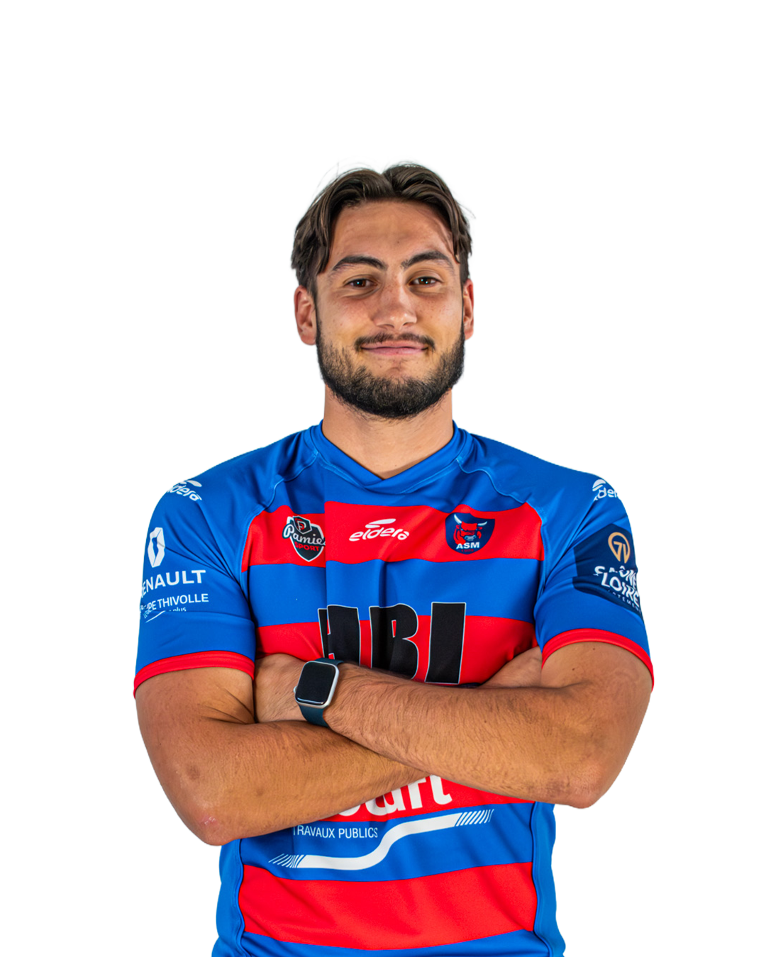 Un homme en maillot de sport bleu, rouge et noir avec ses bras croisés, portant une montre connectée et souriant, avec un logo ASM Rugby sur la poitrine, pose devant un fond neutre.