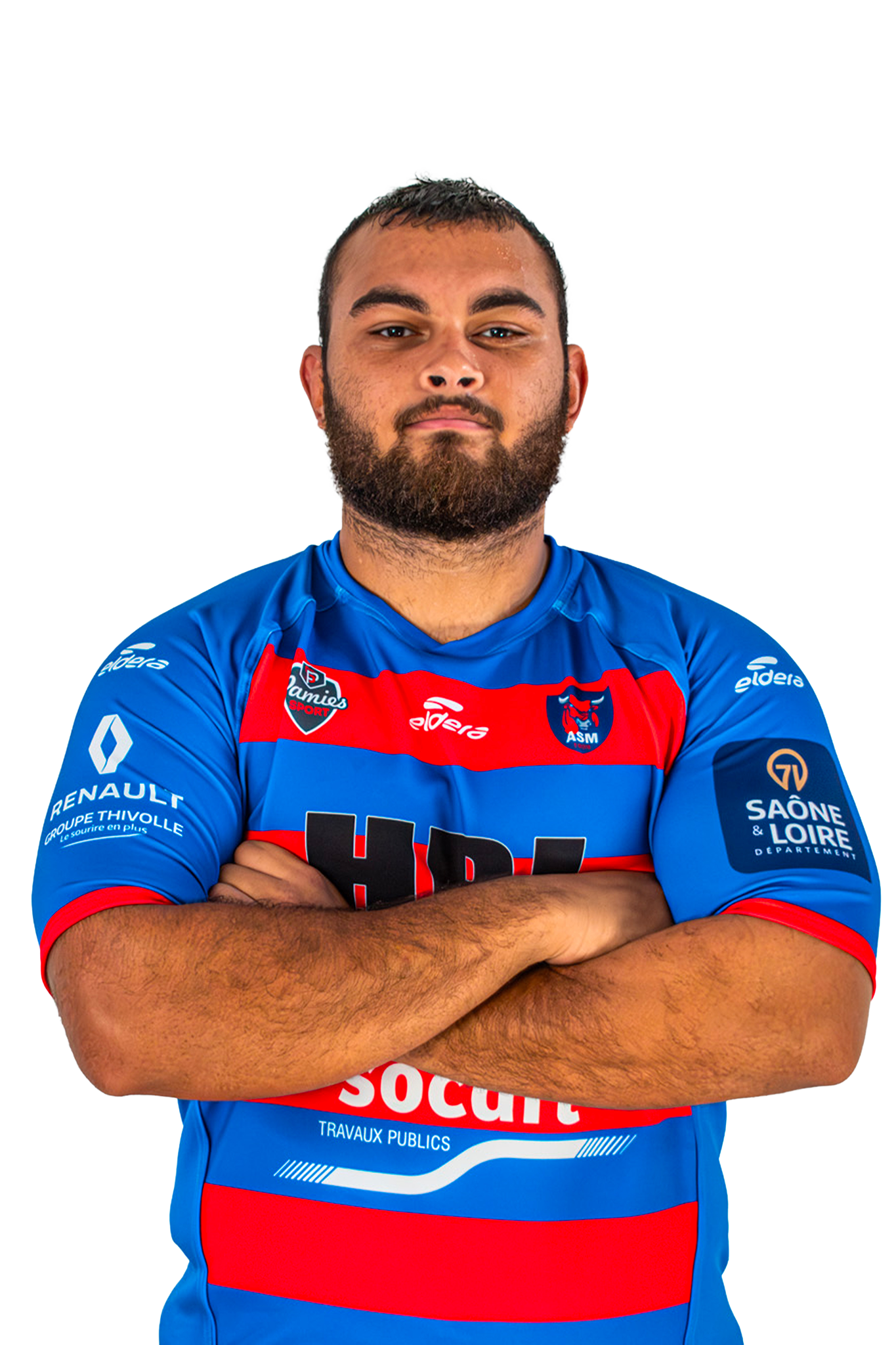 Un homme en maillot de football bleu avec des rayures rouges et des logos, les bras croisés, regardant droit devant.