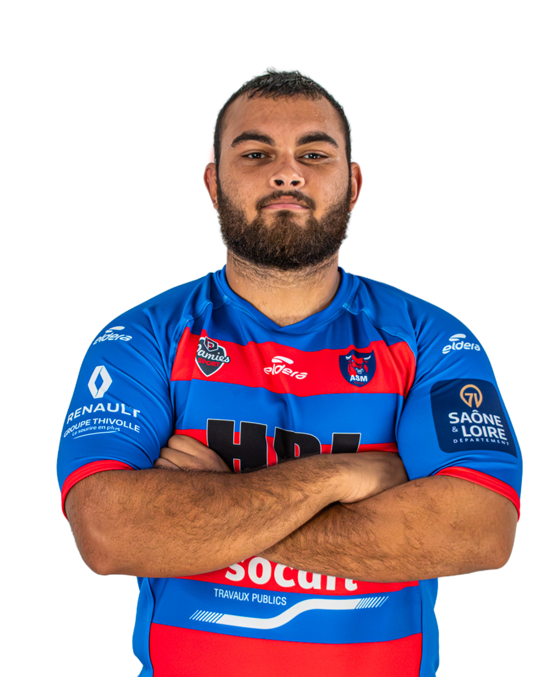 Un joueur de rugby masculin portant un maillot bleu avec des bandes rouges et noires, bras croisés, regardant vers l'avant. Le maillot affiche des logos de sponsors et d'équipe.