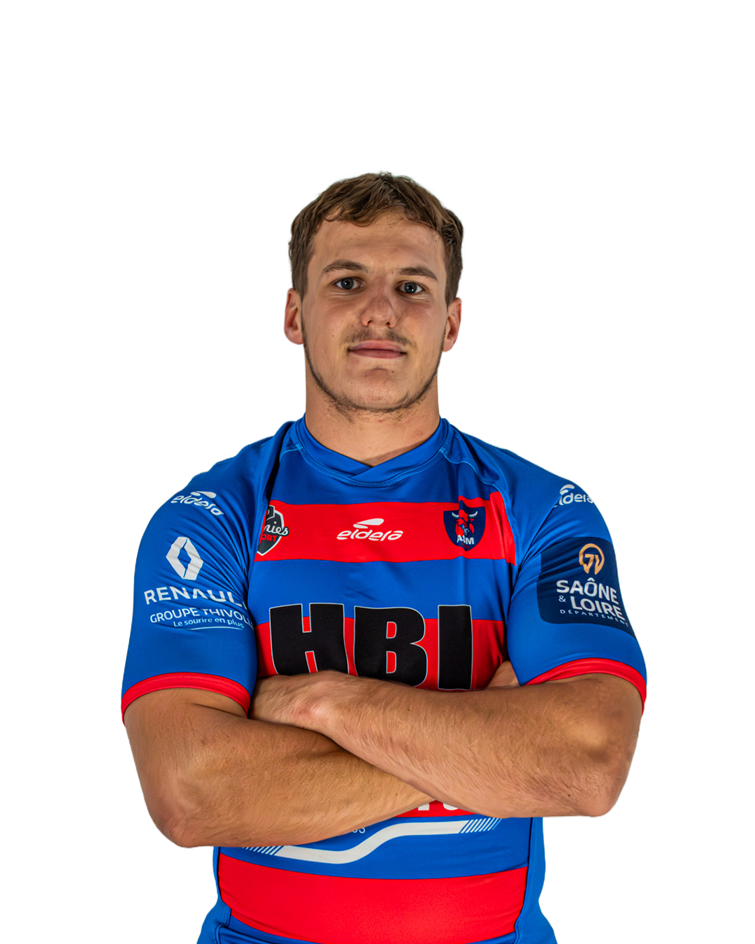 Un homme jeune portant un maillot de rugby bleu avec des logos et des sponsors, croisant les bras, regardant devant lui.