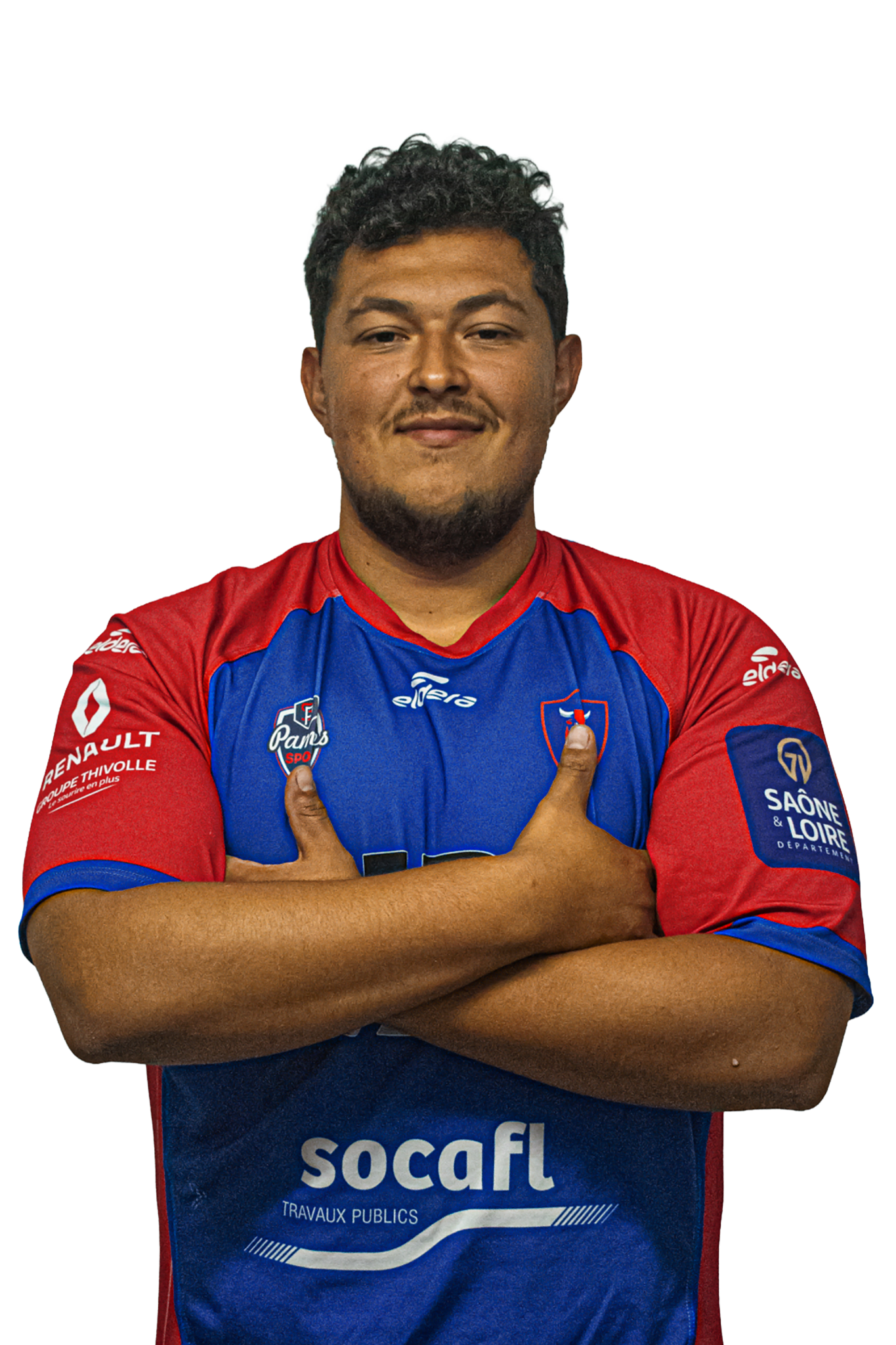 Un homme en maillot de rugby rouge et bleu, avec ses bras croisés, souriant.