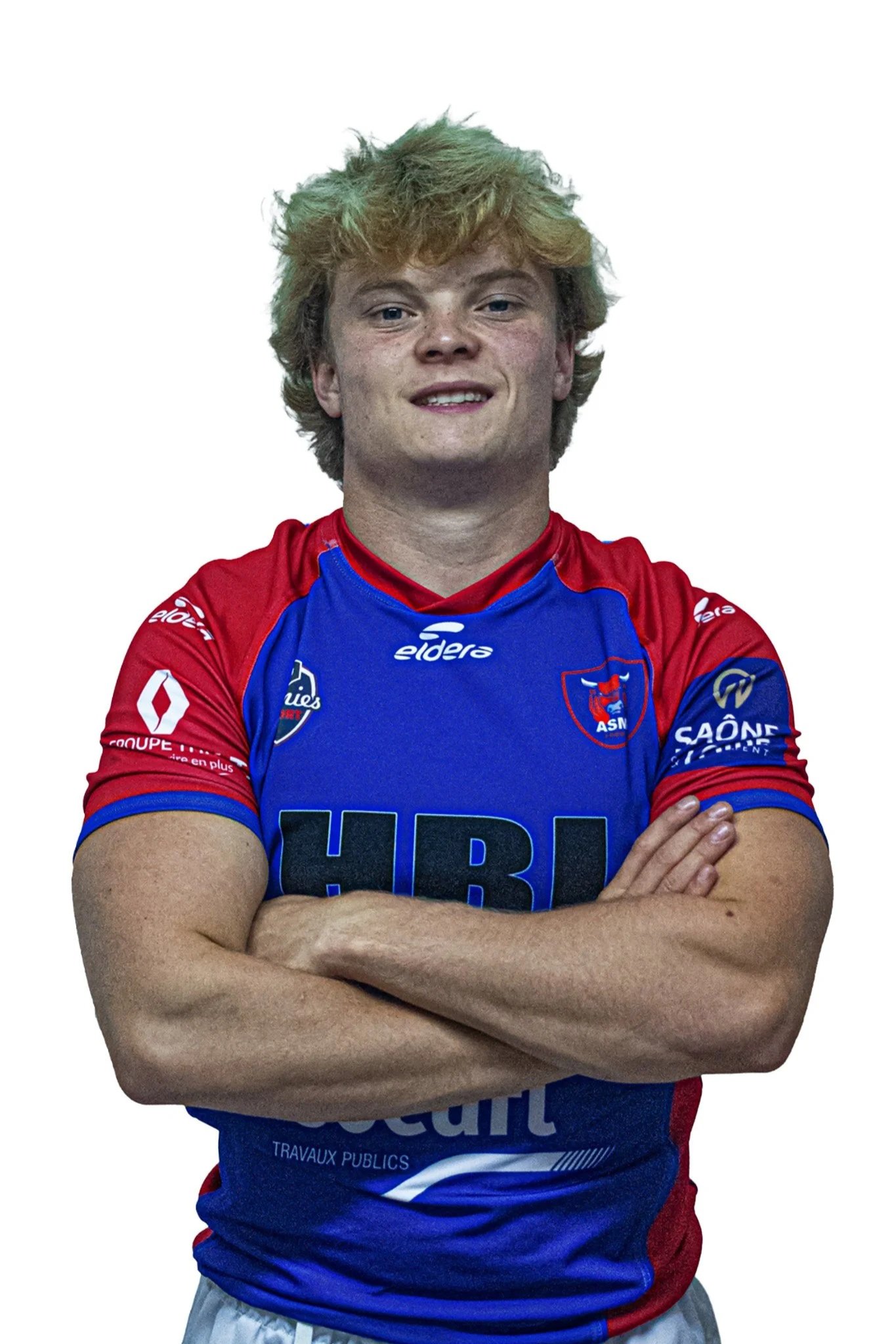 Jeune homme en maillot de rugby bleu et rouge, bras croisés, souriant, sur fond blanc.