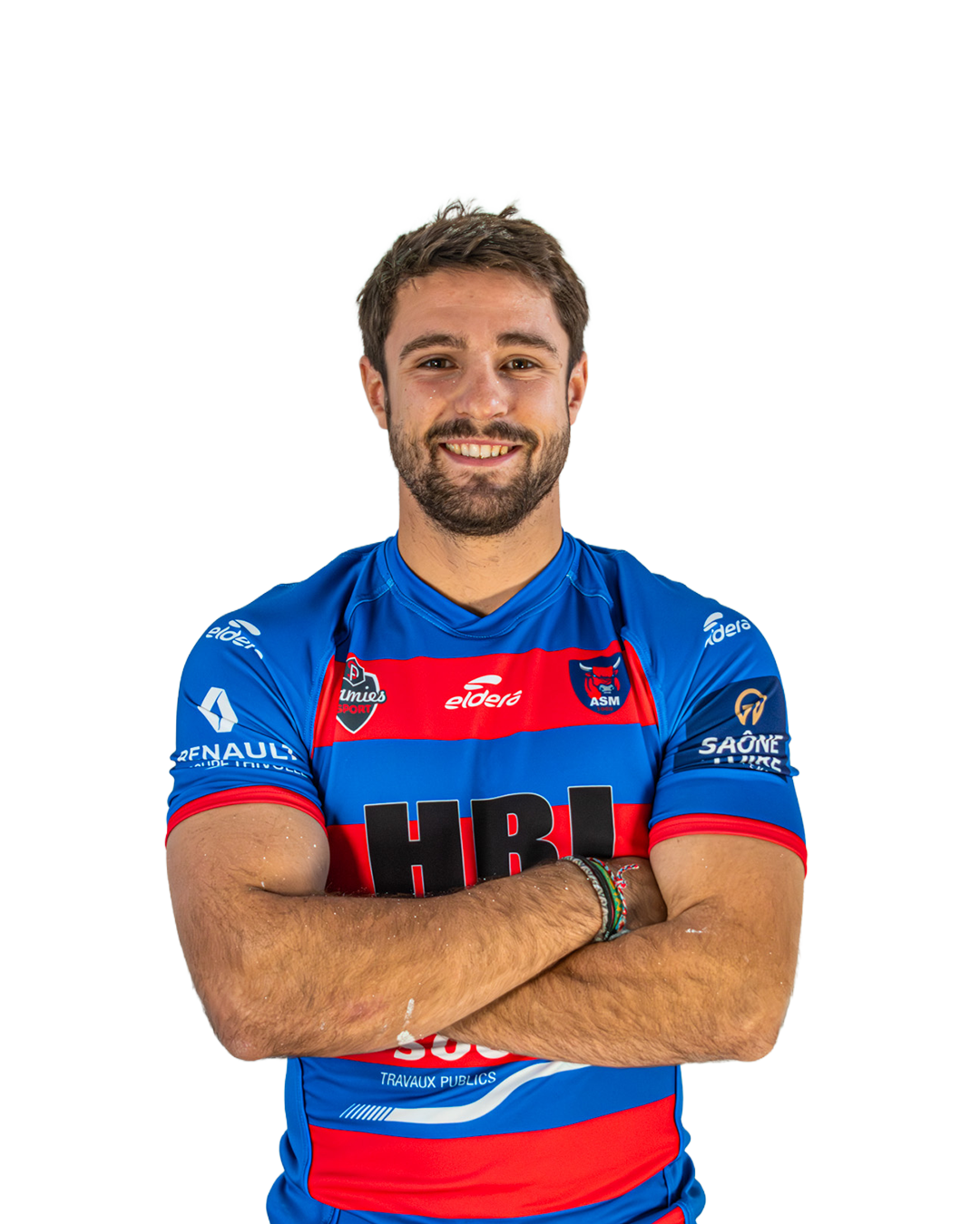 Un homme souriant avec une barbe, portant un maillot de rugby bleu et rouge avec plusieurs logos et sponsors, croisant les bras.