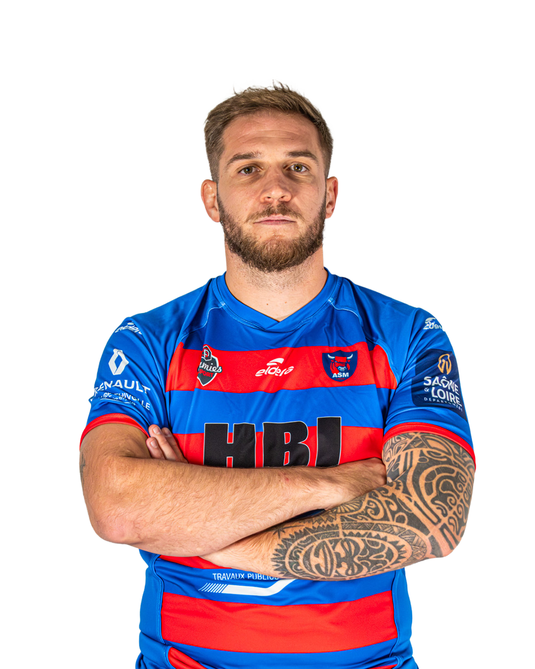 Un homme porte un maillot de rugby bleu avec des bandes rouges, les bras croisés, avec un tatouage sur le bras droit, fond blanc.