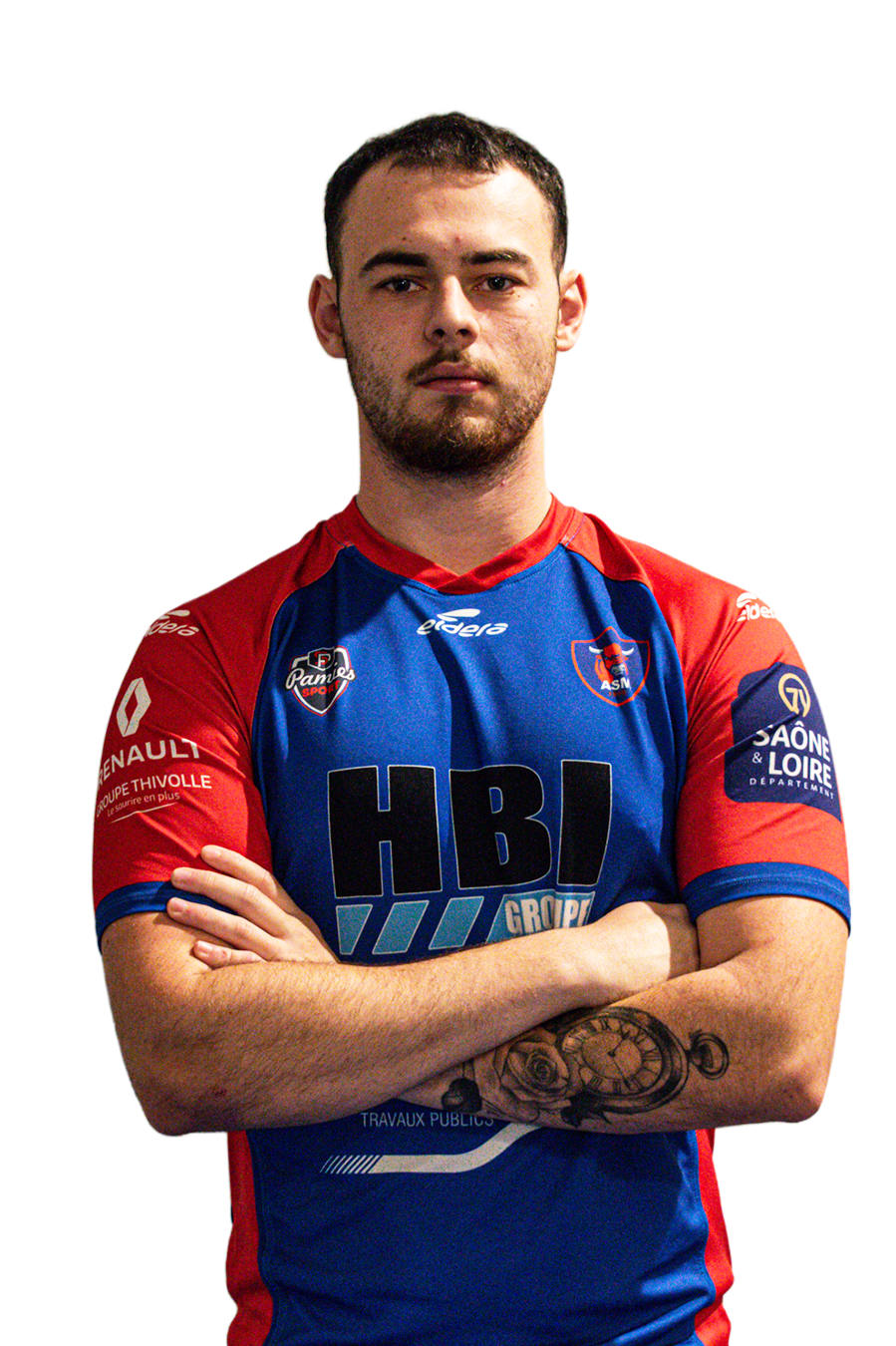 Un homme portant un maillot de football bleu et rouge avec ses bras croisés, montrant un tatouage sur le bras gauche.