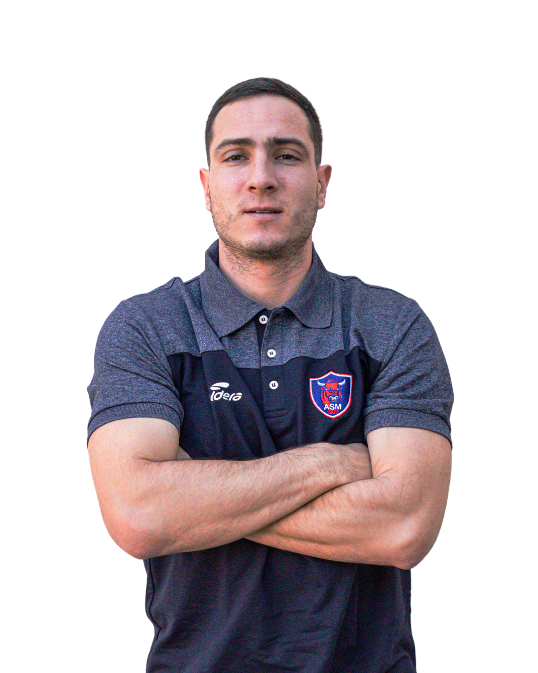 Un jeune homme avec les bras croisés, portant un polo à manches courtes gris et noir avec un logo d'une équipe de football.