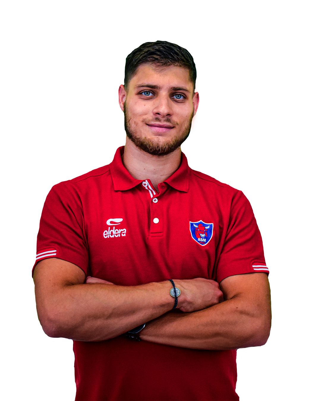 Un jeune homme avec une barbe, portant un maillot de sport rouge de l'équipe ASM, avec le logo ASM et la marque Eldera, croise les bras, souriant légèrement.