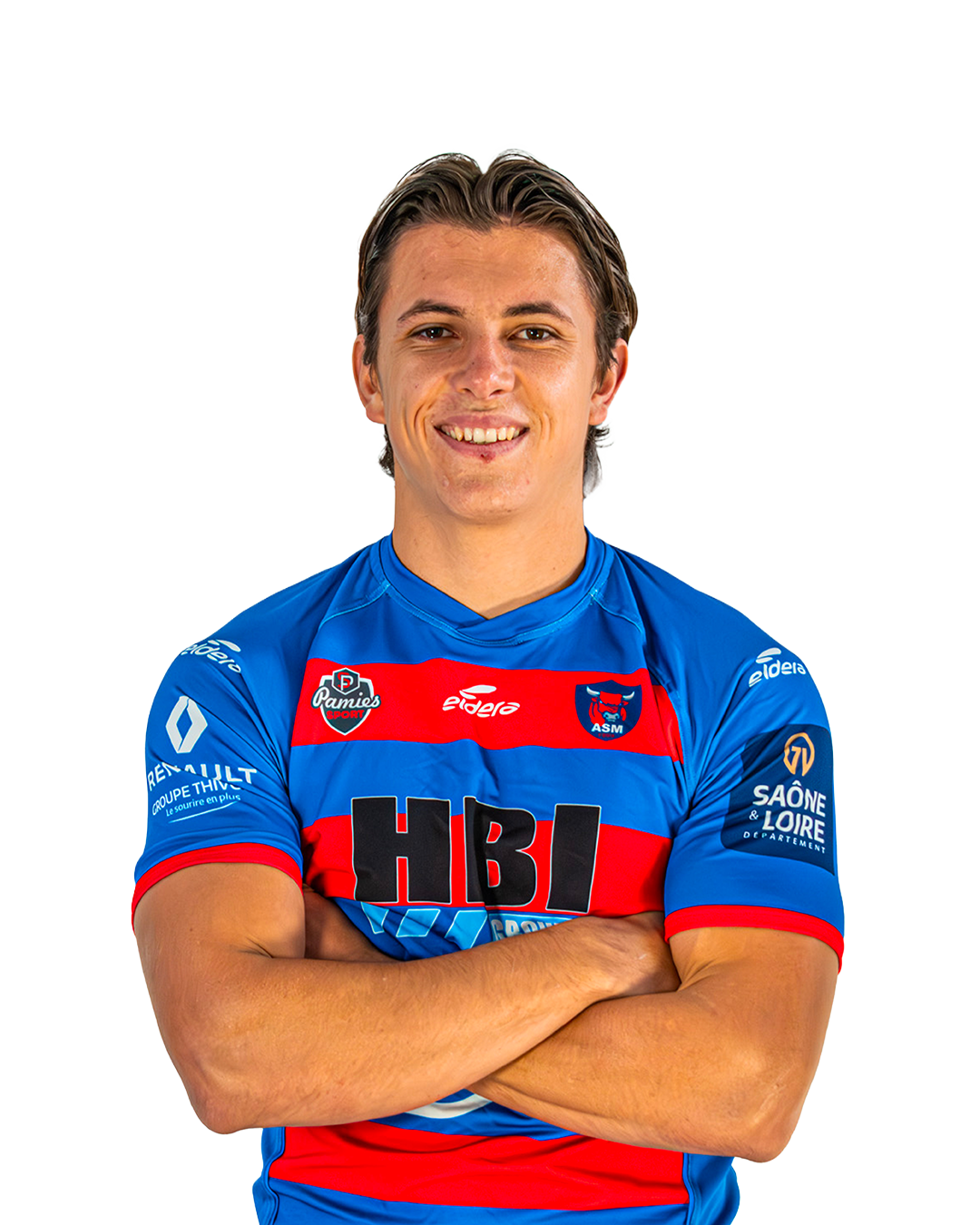 Un jeune homme portant un maillot de football bleu avec des logos sportifs et des sponsors, souriant avec les bras croisés.