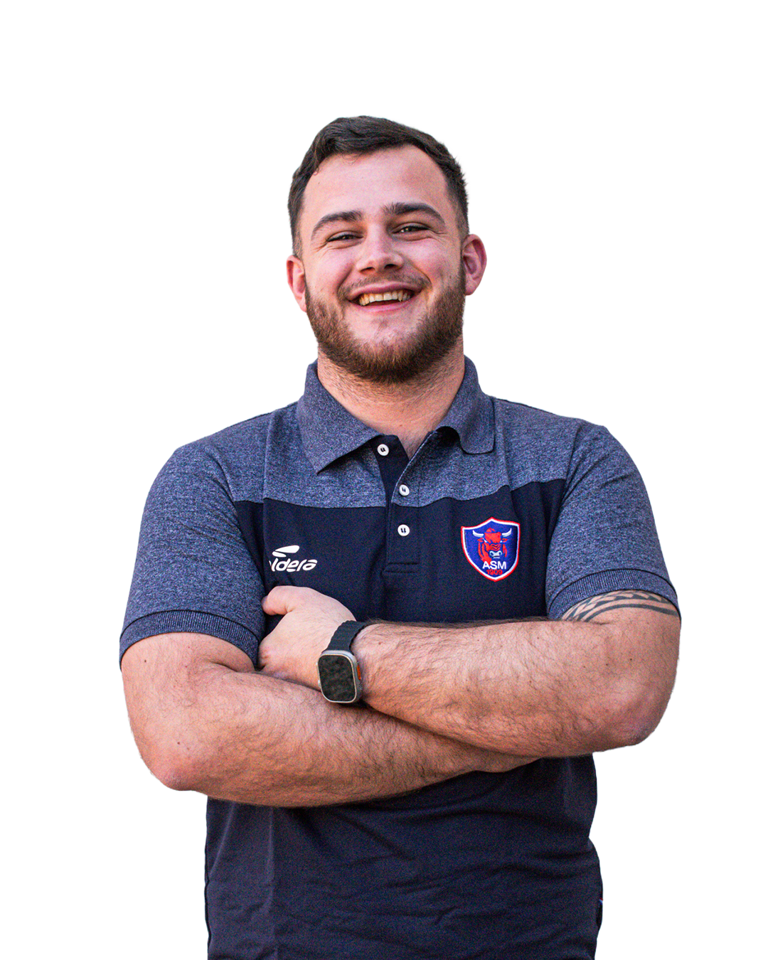 Un homme souriant avec un blazer en croix, portant une montre et un logo de club sportif ASM sur sa chemise, avec un bras tatoué.