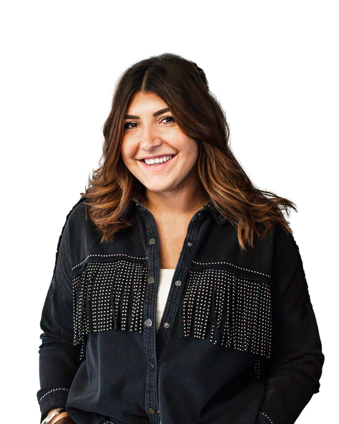 Une femme souriante avec des cheveux bruns, portant une chemise en denim noir décorée de boutonnages et de petits brillants.