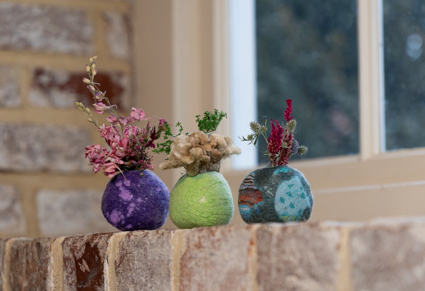 Dried flowers in colorful round handmade vases from Straw Hill Studio