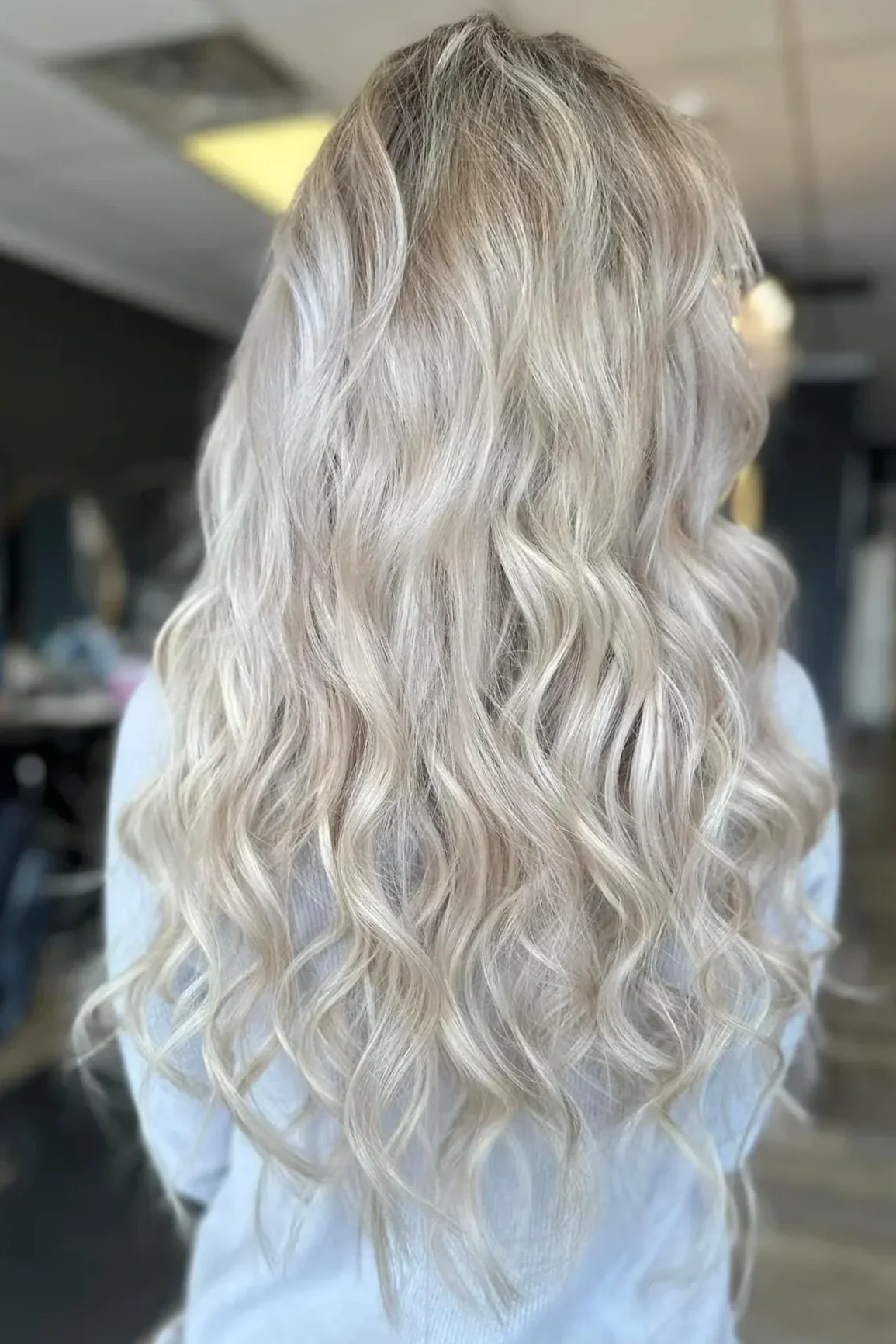 Side view of a woman with long, blonde, wavy hair.